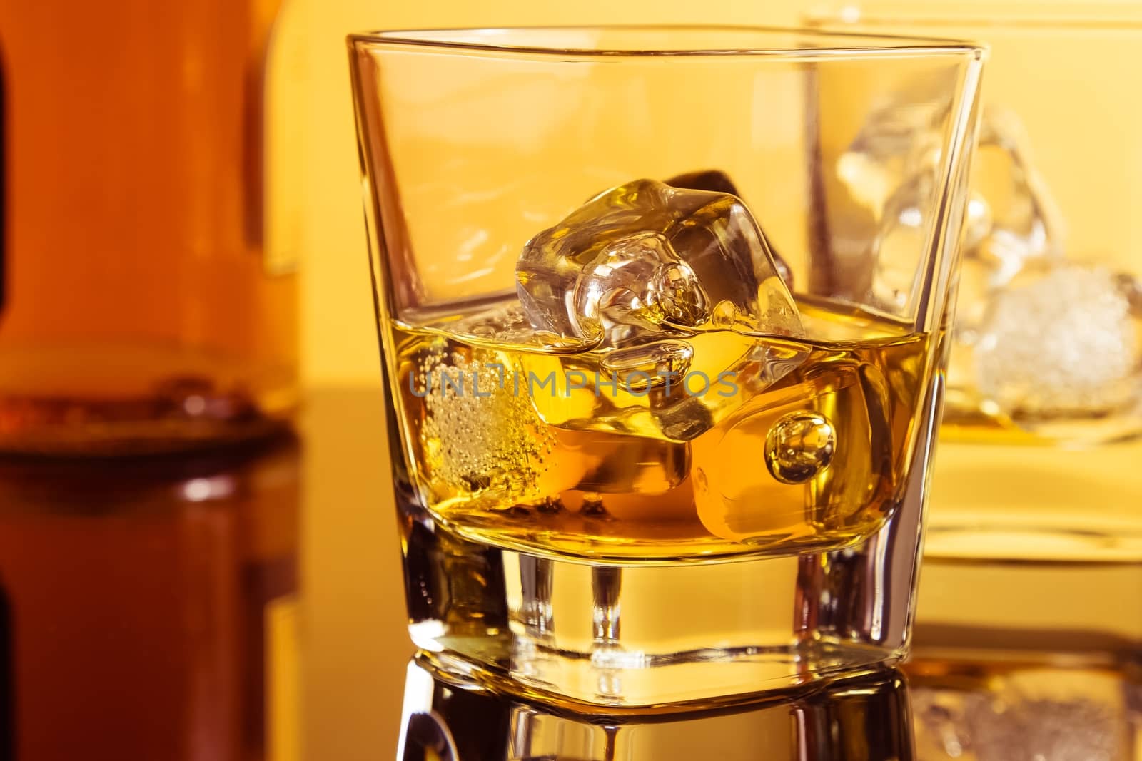 close-up of two glasses of whiskey near bottle on table with reflection, warm atmosphere, time of relax with whisky