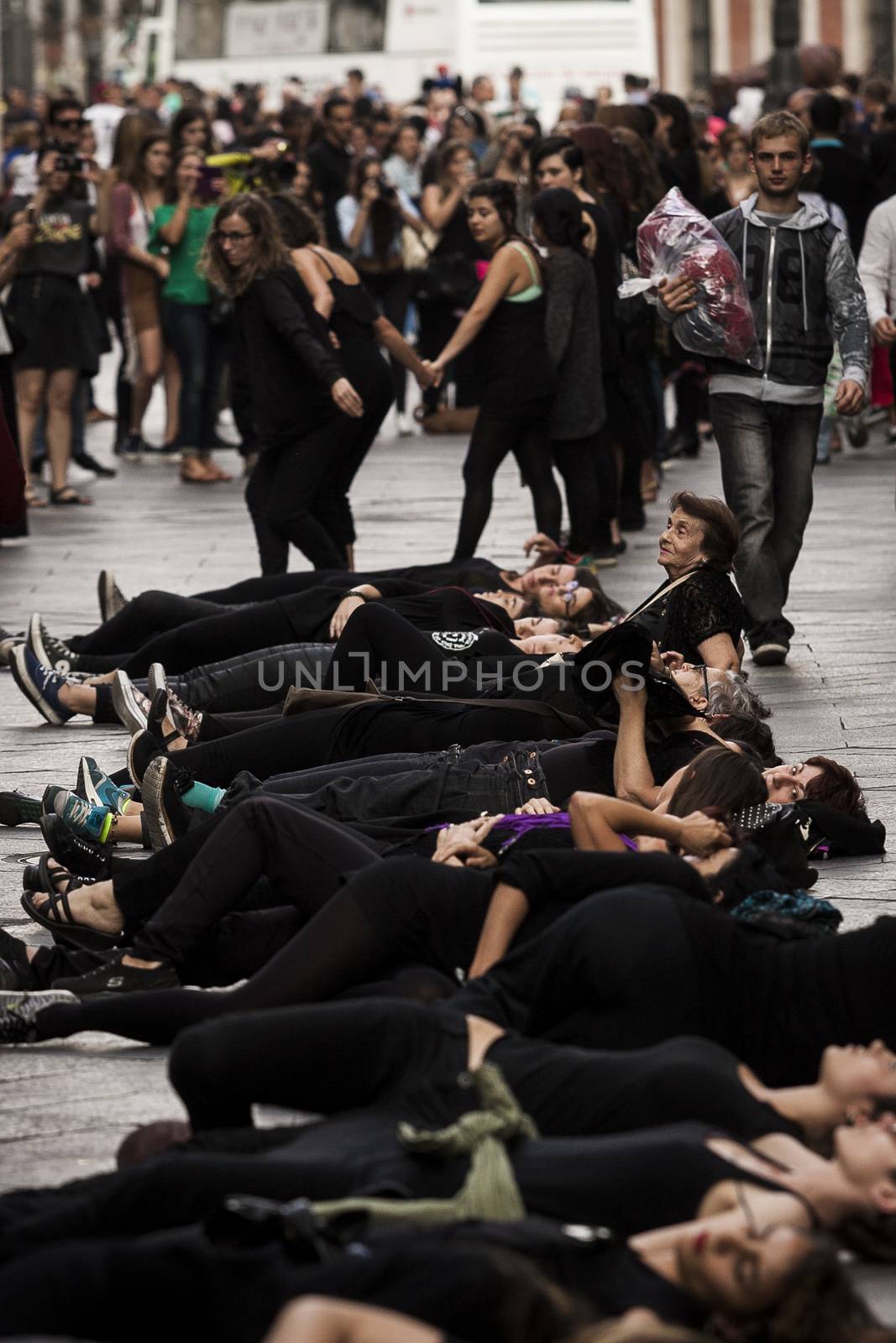 SPAIN, Madrid: Women dressed in all black feign their own death in downtown Madrid as part of a performance protest, on October 2, 2015, denouncing gender-based violence. 