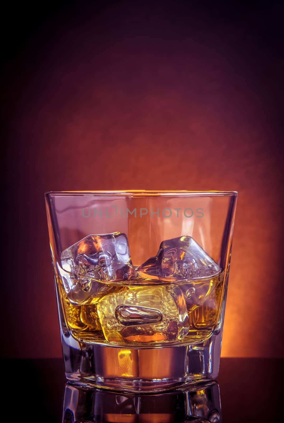 glass of whiskey on black table with reflection, violet light tint atmosphere, time of relax with whisky