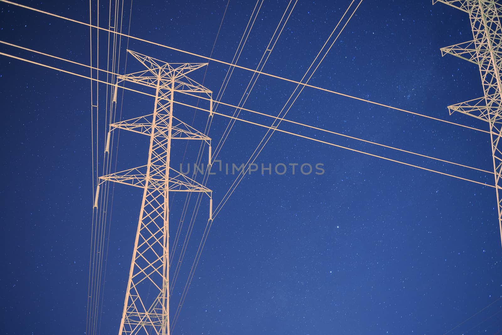 High voltage power tower at night with stars in the background in Brisbane, Queensland. 