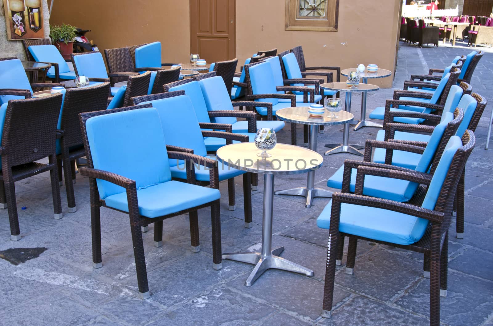 Rows of blue chairs and metallic tables in a caffe