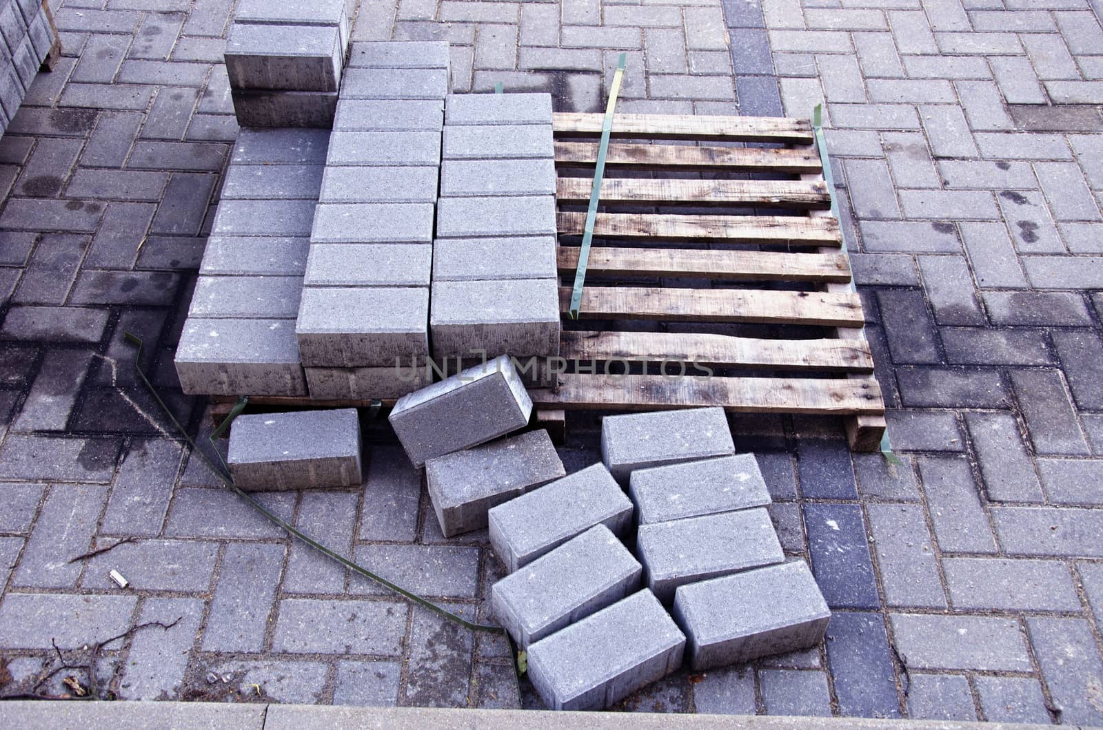 Pallet with few rows of concrete grey pavement blocks bricks in street