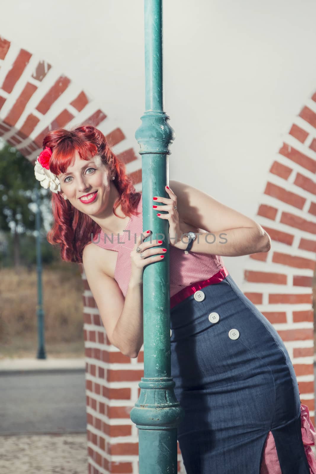View of pinup young woman in vintage style clothing peeking on a playful way.