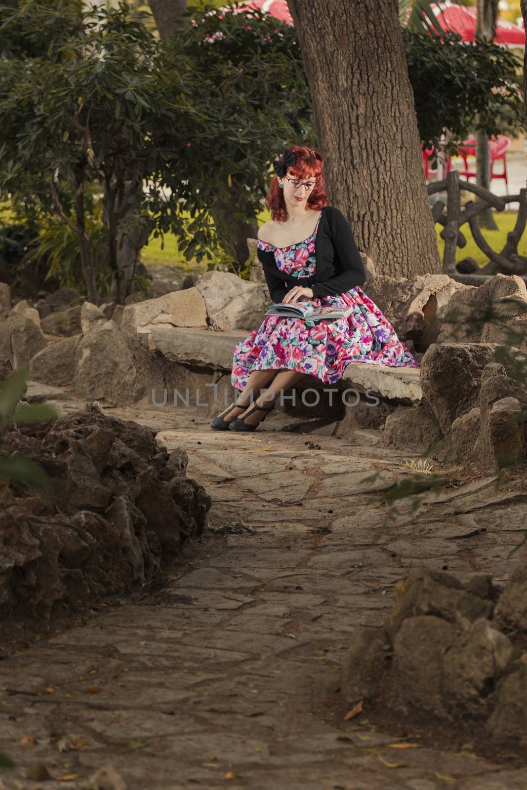 View of pinup young woman in vintage style clothing on a city park.