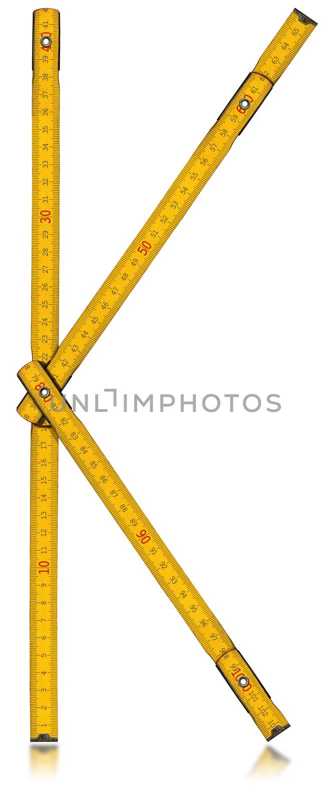 Old wooden yellow meter in the shape of letter K. Isolated on white background.