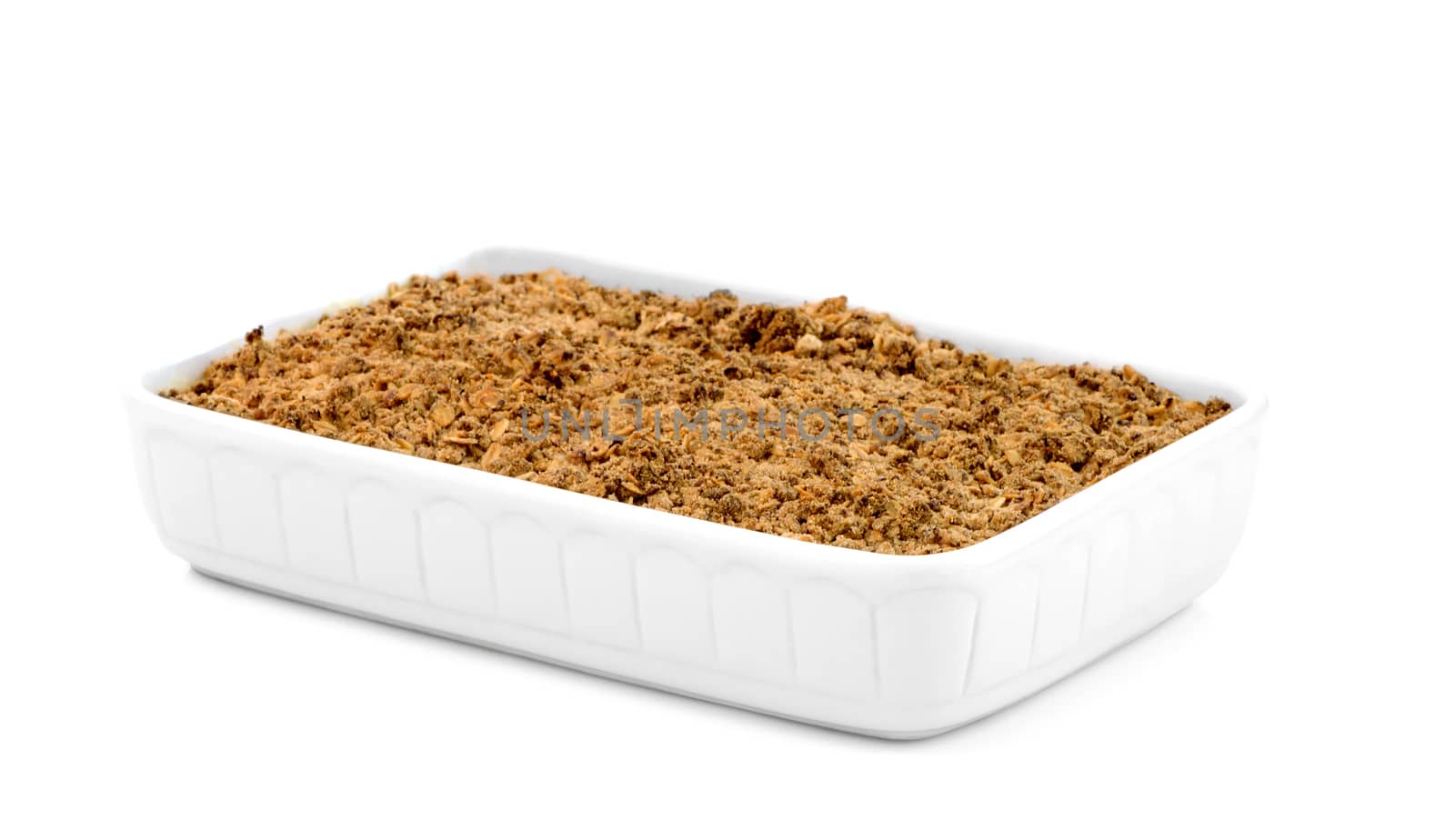 Apple crumble in a white ceramic pan isolated on white background.