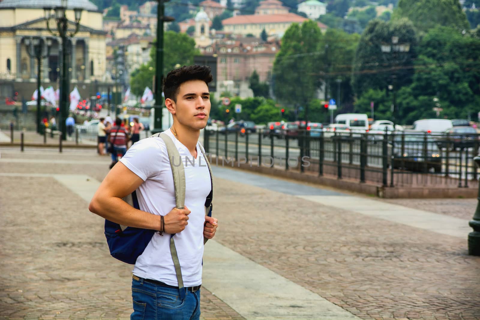 Handsome young man walking in European city square, Piazza Vittorio Veneto in Turin, Italy