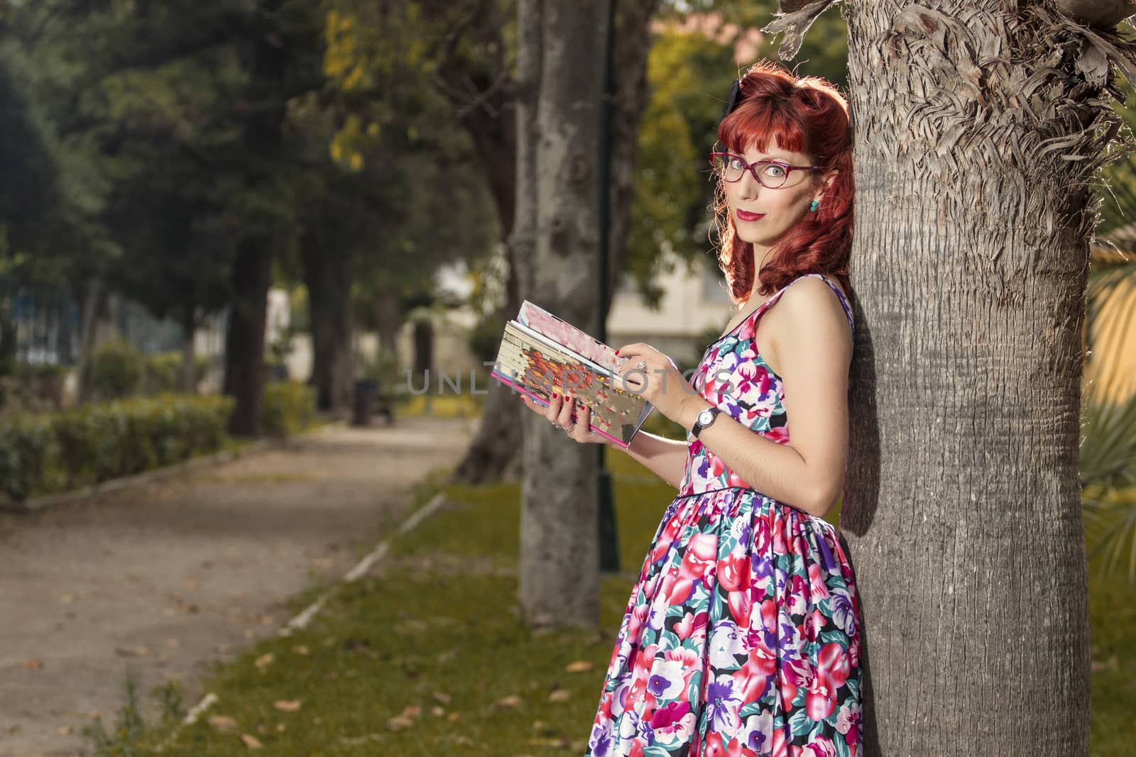 View of pinup young woman in vintage style clothing reading a book.