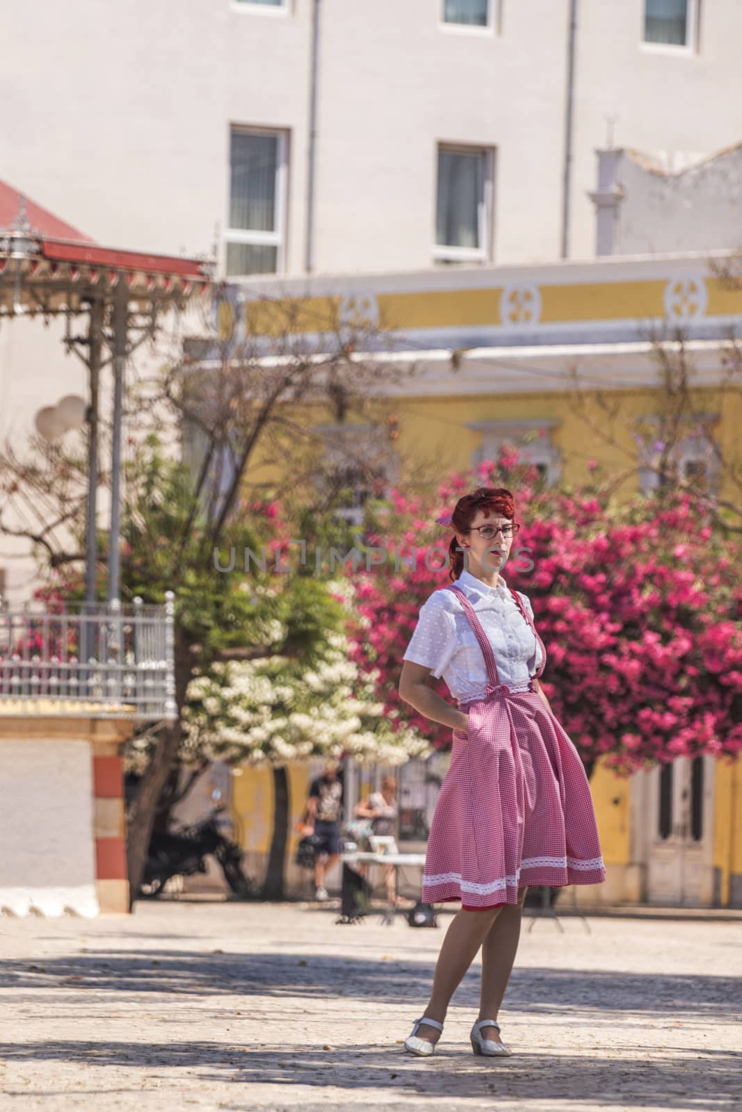 View of pinup young woman in vintage style clothing on the streets of Faro city.