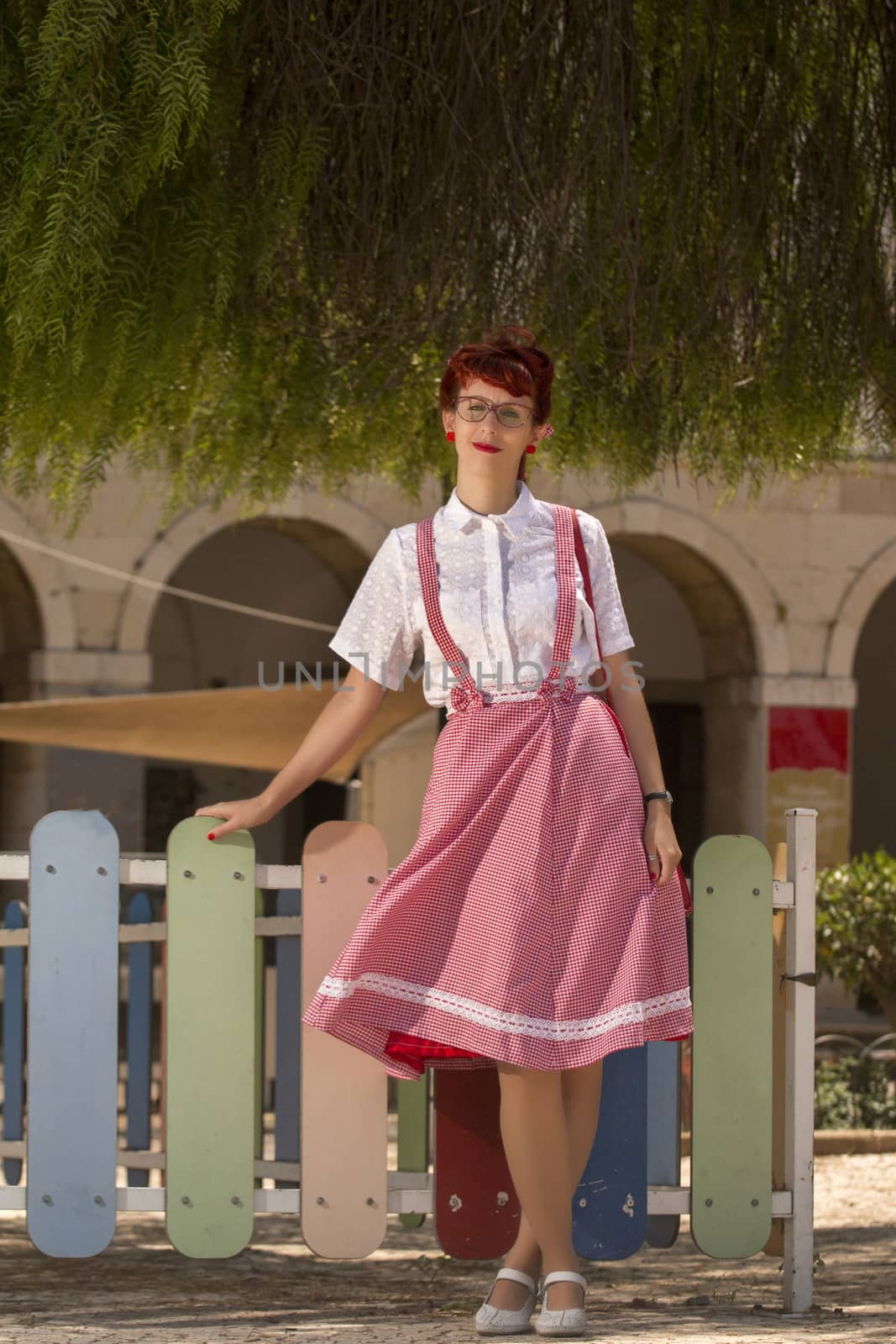 View of pinup young woman in vintage style clothing on the streets of Faro city.