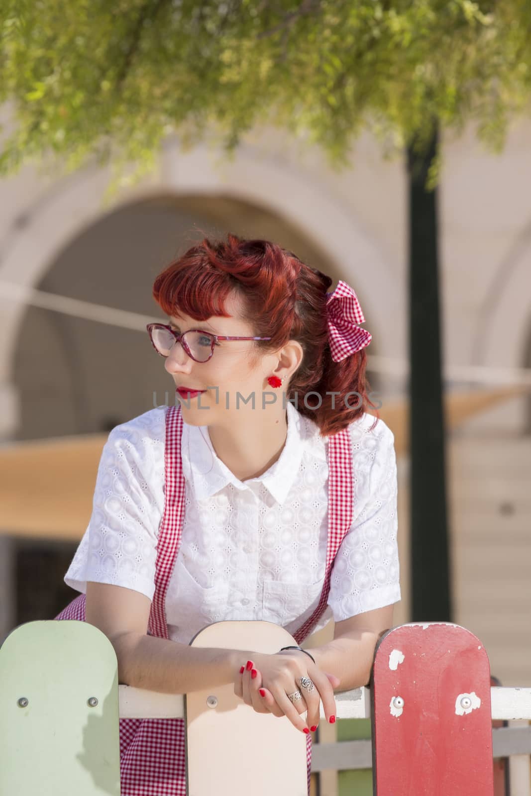 View of pinup young woman in vintage style clothing on the streets of Faro city.