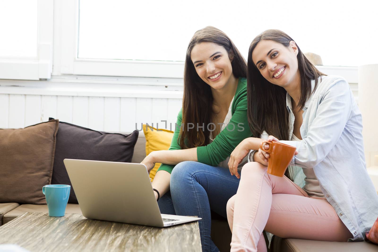 Female friends at the local coffee shop drinking coffee and working