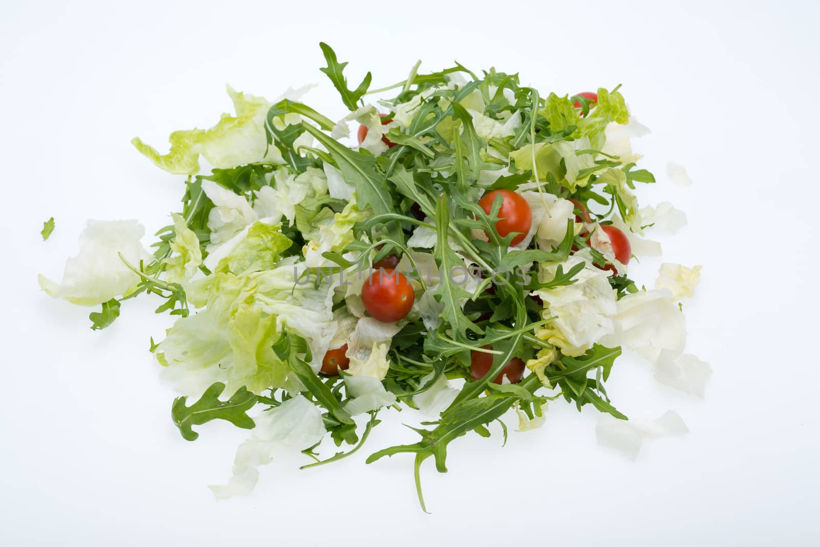 Heap of ruccola, lettuce leaves and cherry tomatoes