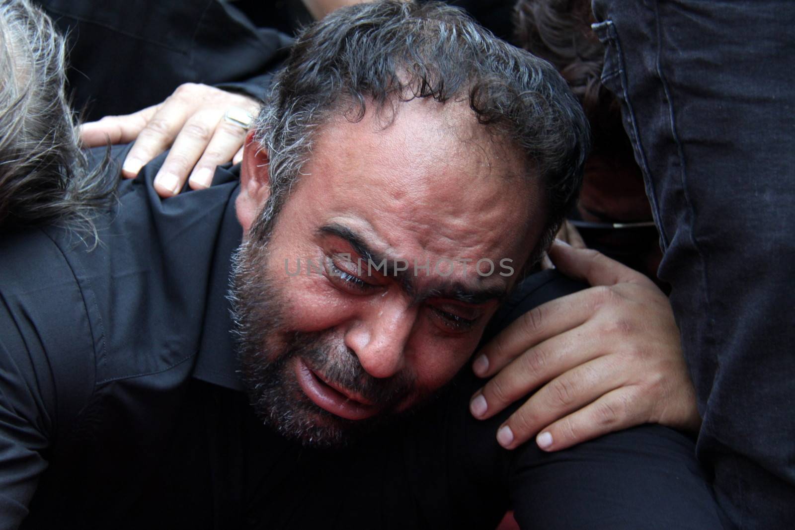 IRAN, Tehran: A man cries as family and friends gather at the Behesht-e Zahra cemetery on October 4, 2015 to say their final farewells to loved ones lost in the Mena tragedy. A total of 465 Iranian pilgrims lost their lives in the large stampede of people at the Hajj rituals on September 24, 2015. The pilgrims were on their way to participate in the symbolic stoning of the Satan in the Mena neighbourhood of Mecca, Saudi Arabia. 