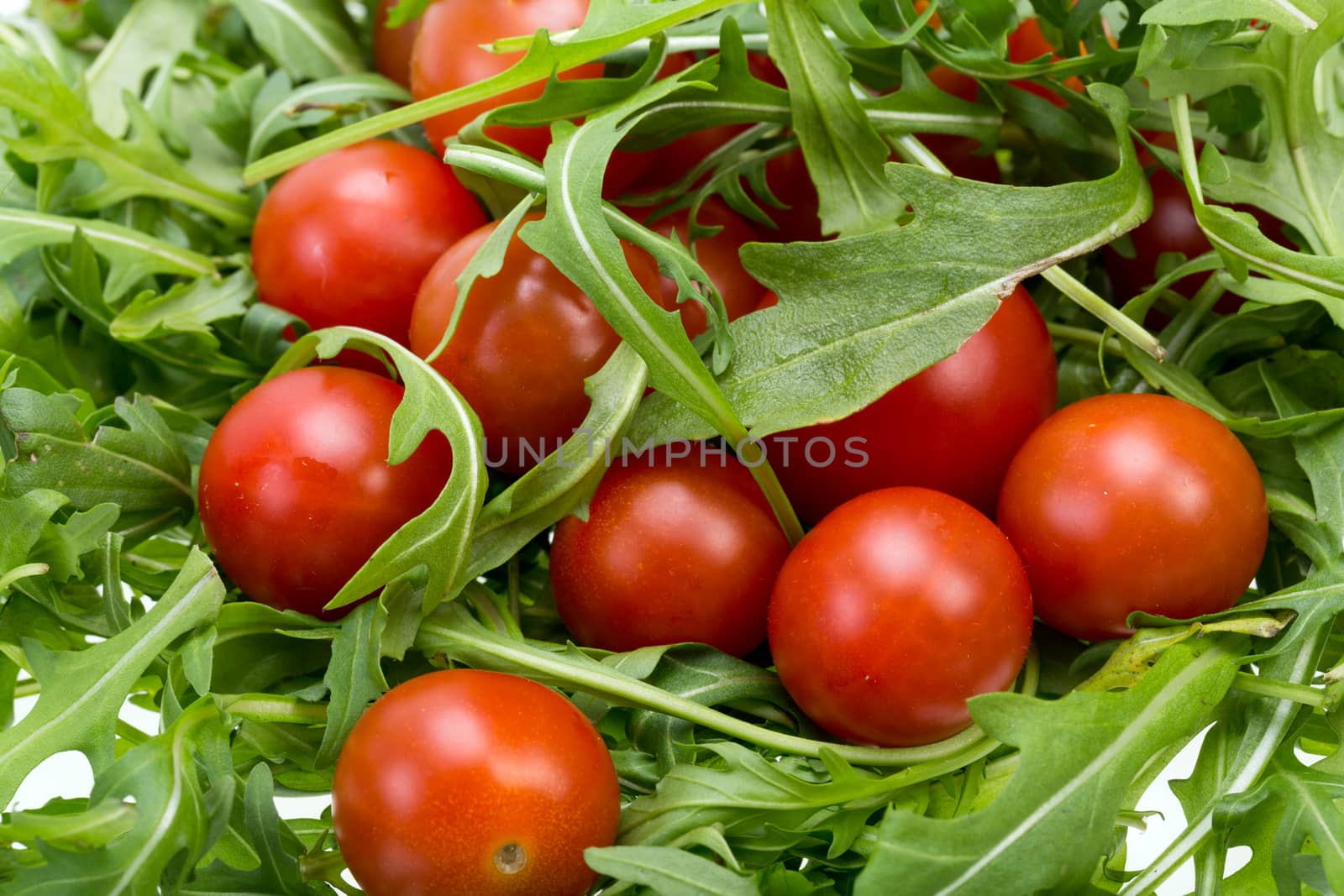 Heap of ruccola leaves and cherry tomatoes