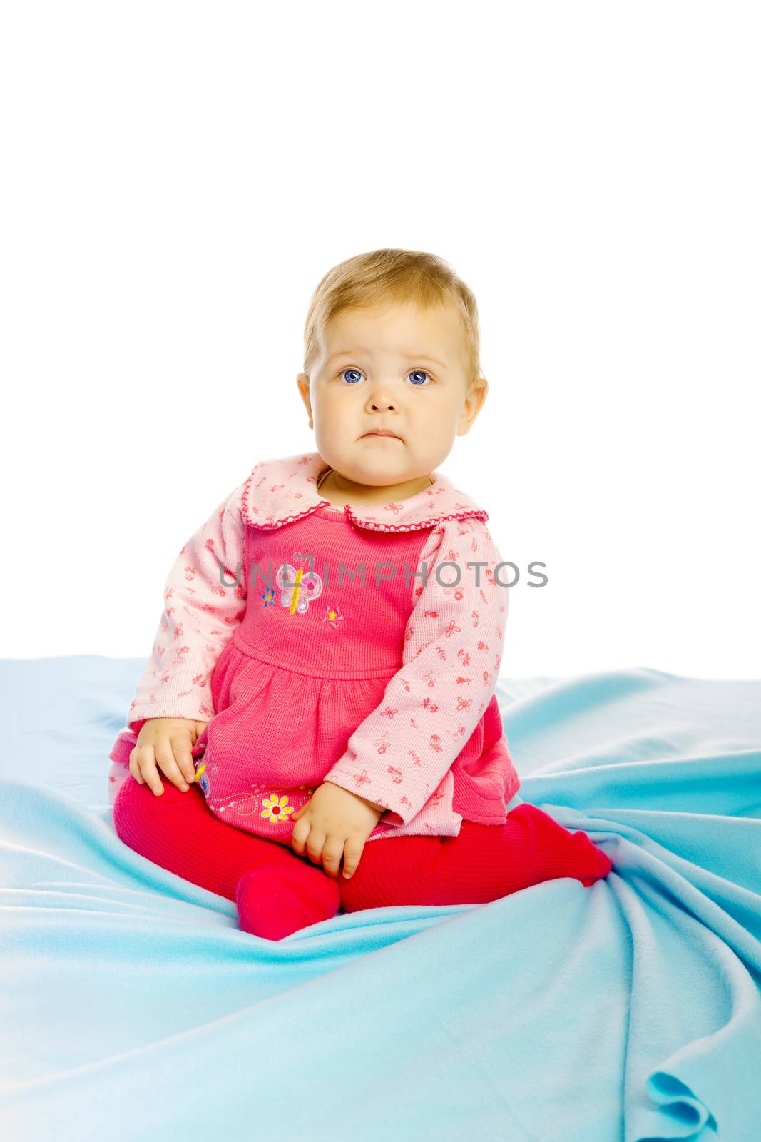 Little girl baby in a dress sitting on the floor