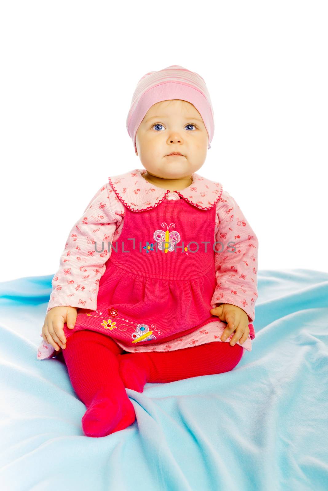 Little girl baby in a dress sitting on the floor