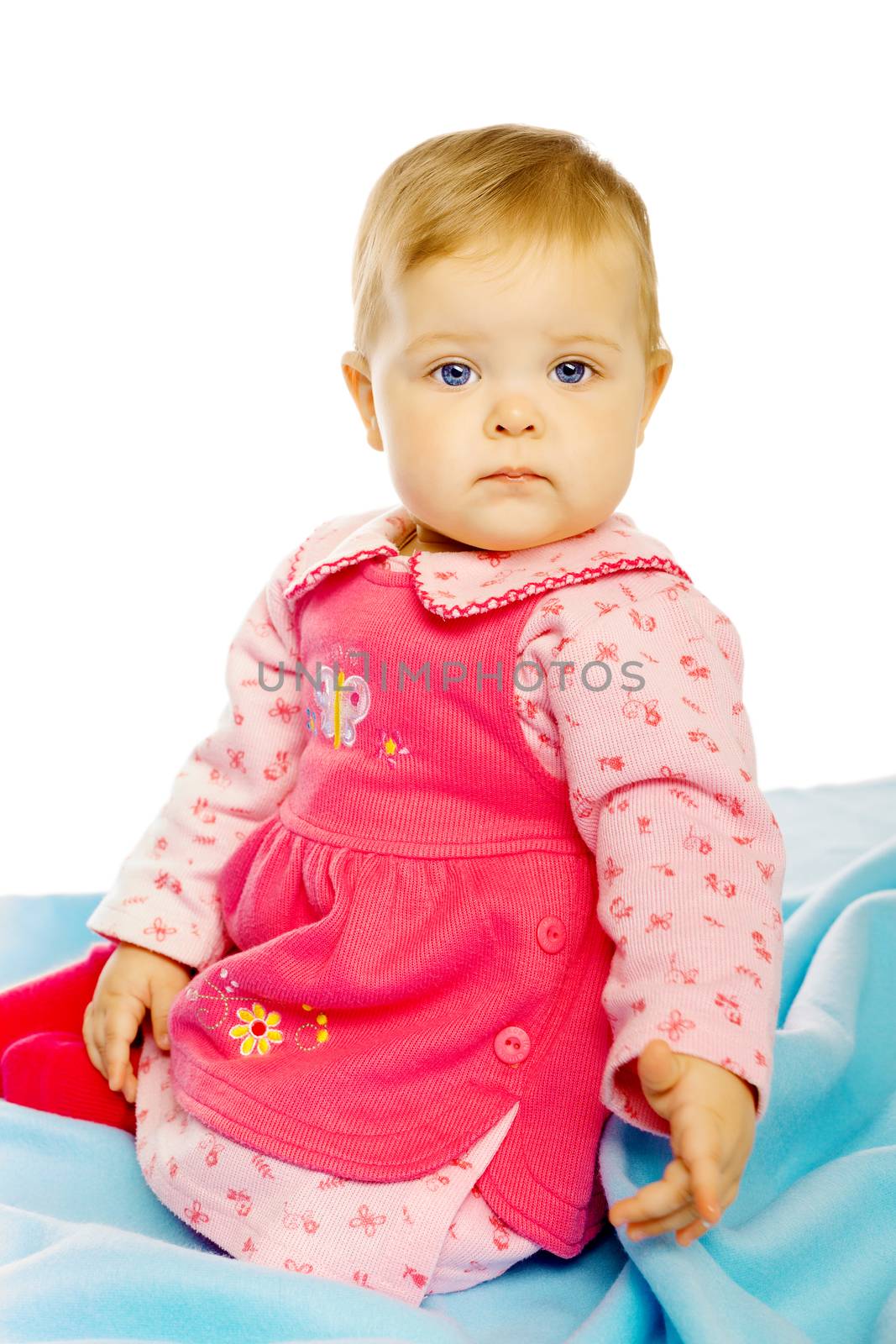 Little girl baby in a dress sitting on the floor