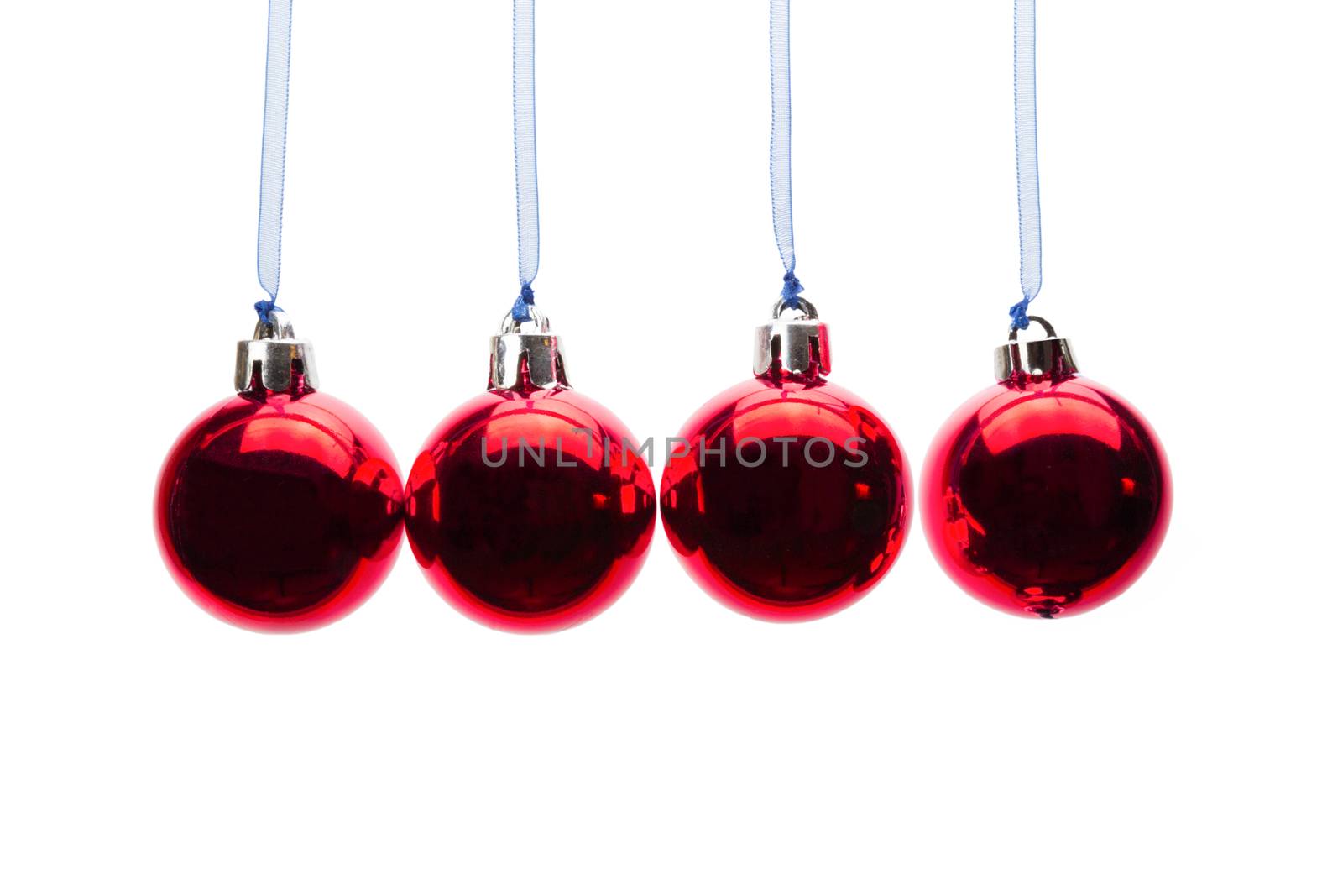 Four red christmas balls hanging in a horizontal row isolated on white background