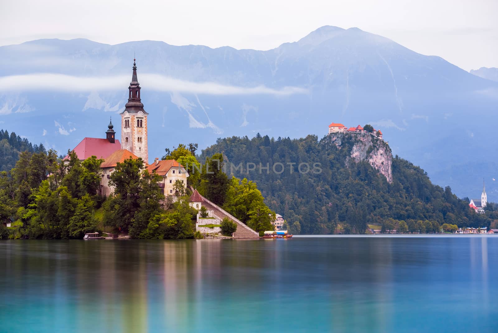 Little Island with Catholic Church and Bled Castle on Bled Lake, Slovenia with Mountains in Background
