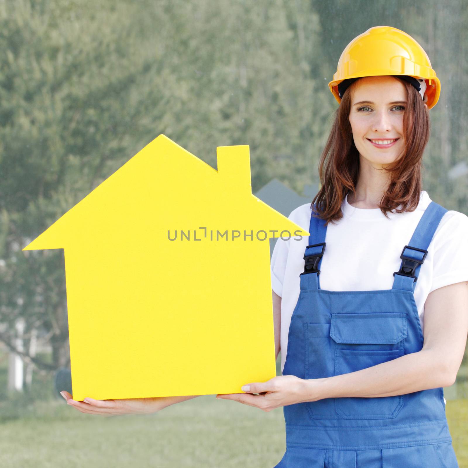 Happy female worker holding a house model