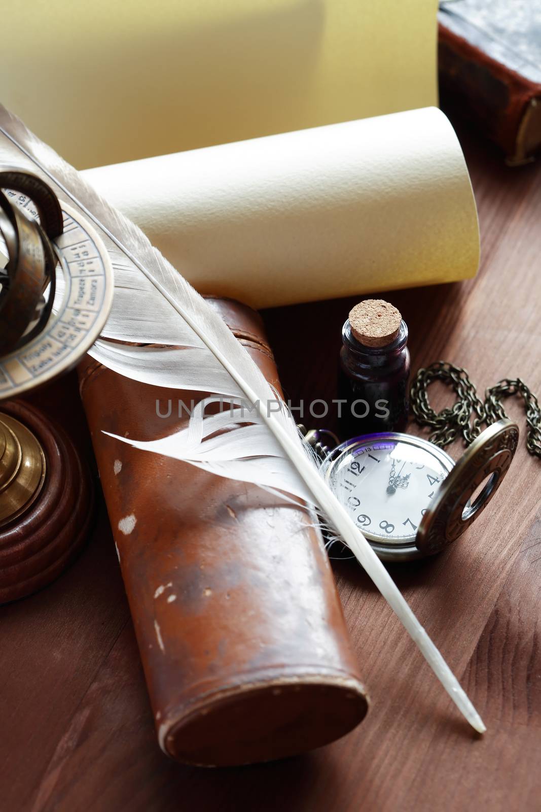 Vintage still life. Quill pen near scroll and other vintage things