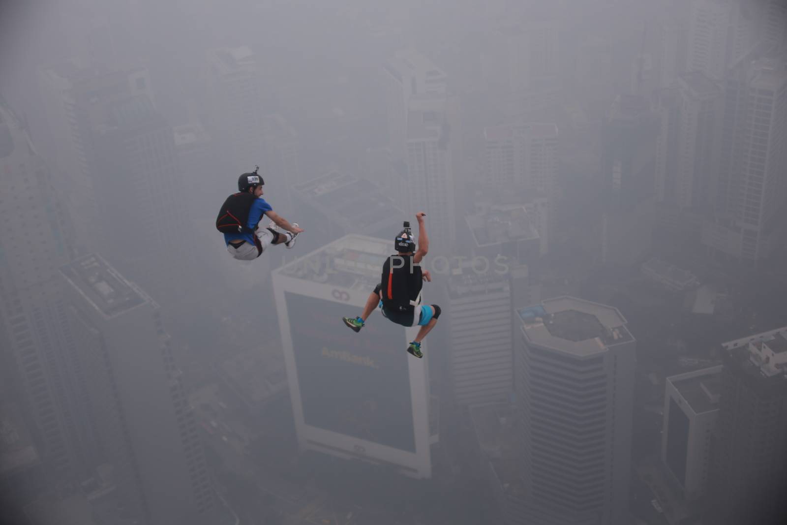 MALAYSIA, Kuala Lumpur: Base jumper pair leap into haze	Heavy haze didn't deter the 120 thrill-seeking base jumpers as they leapt into the foggy abyss off Kuala Lumpur Tower on October 3, 2015.  	The participants were joining others across the world on the 15th�International Base Jump Day. 
