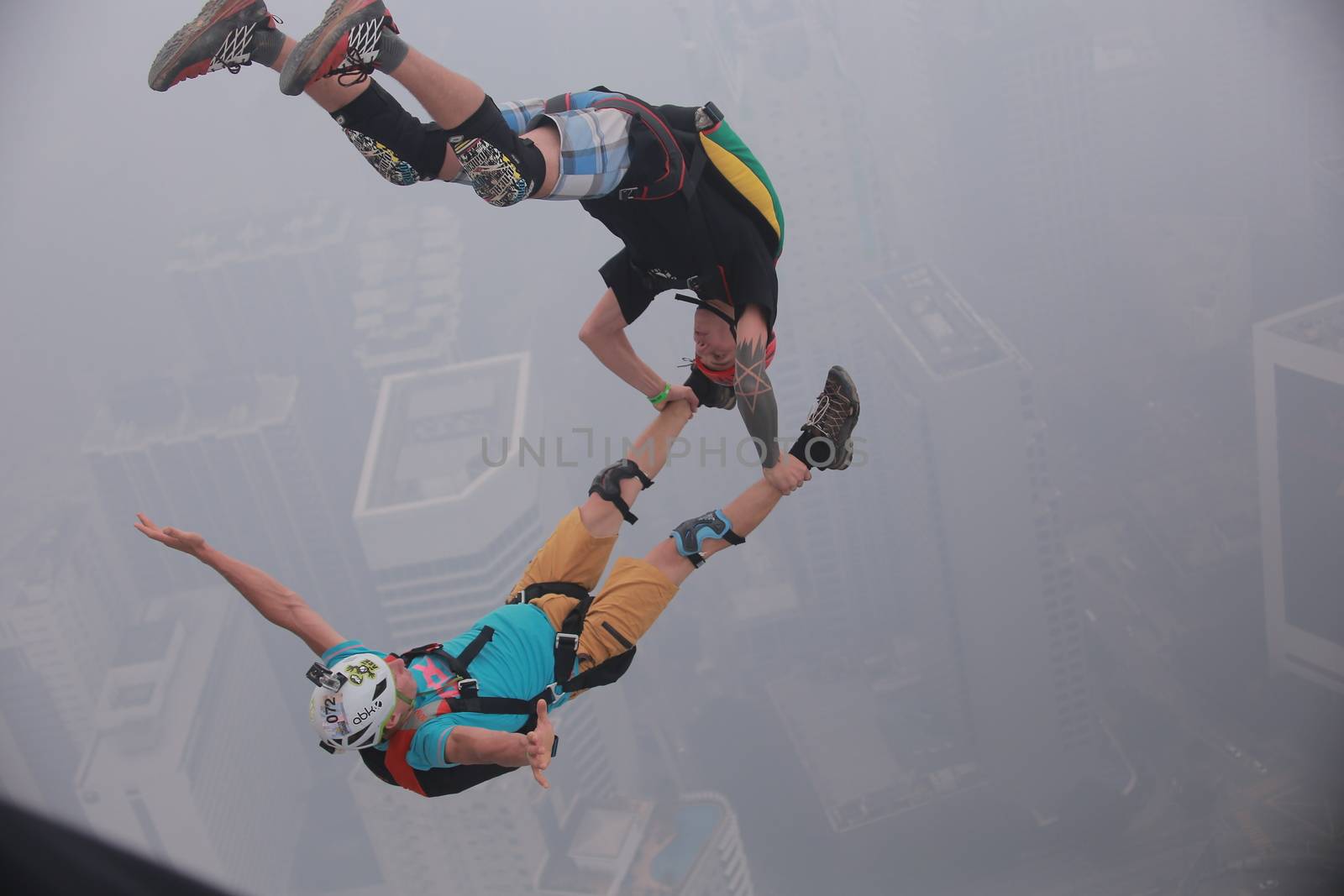 MALAYSIA, Kuala Lumpur: Base jumper pair leap	Heavy haze didn't deter the 120 thrill-seeking base jumpers as they leapt into the foggy abyss off Kuala Lumpur Tower on October 3, 2015.  	The participants were joining others across the world on the 15th�International Base Jump Day. 