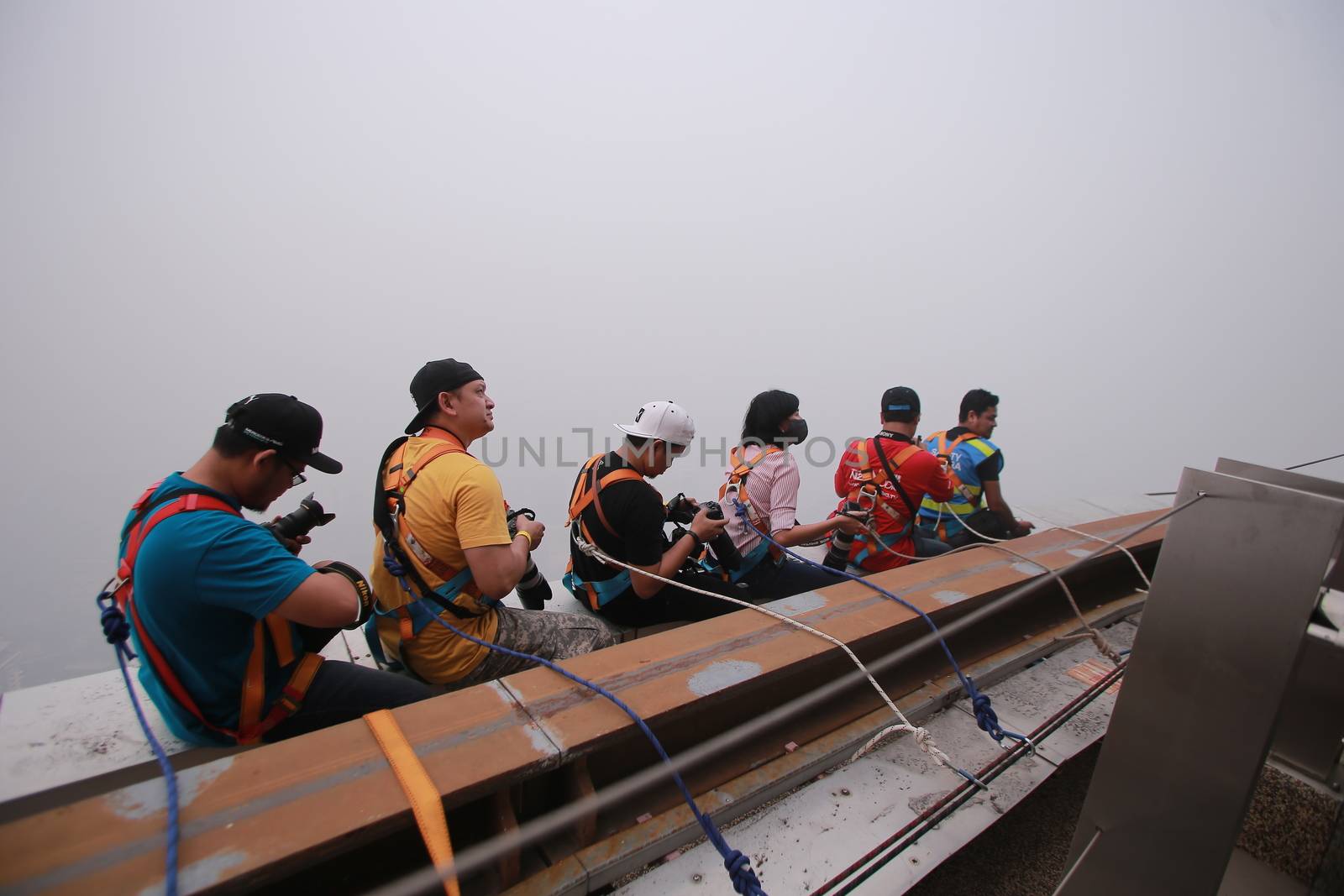 MALAYSIA, Kuala Lumpur: Photographer's anchored onto top of KL Tower	Heavy haze didn't deter the 120 thrill-seeking base jumpers as they leapt into the foggy abyss off Kuala Lumpur Tower on October 3, 2015.  	The participants were joining others across the world on the 15th�International Base Jump Day. 