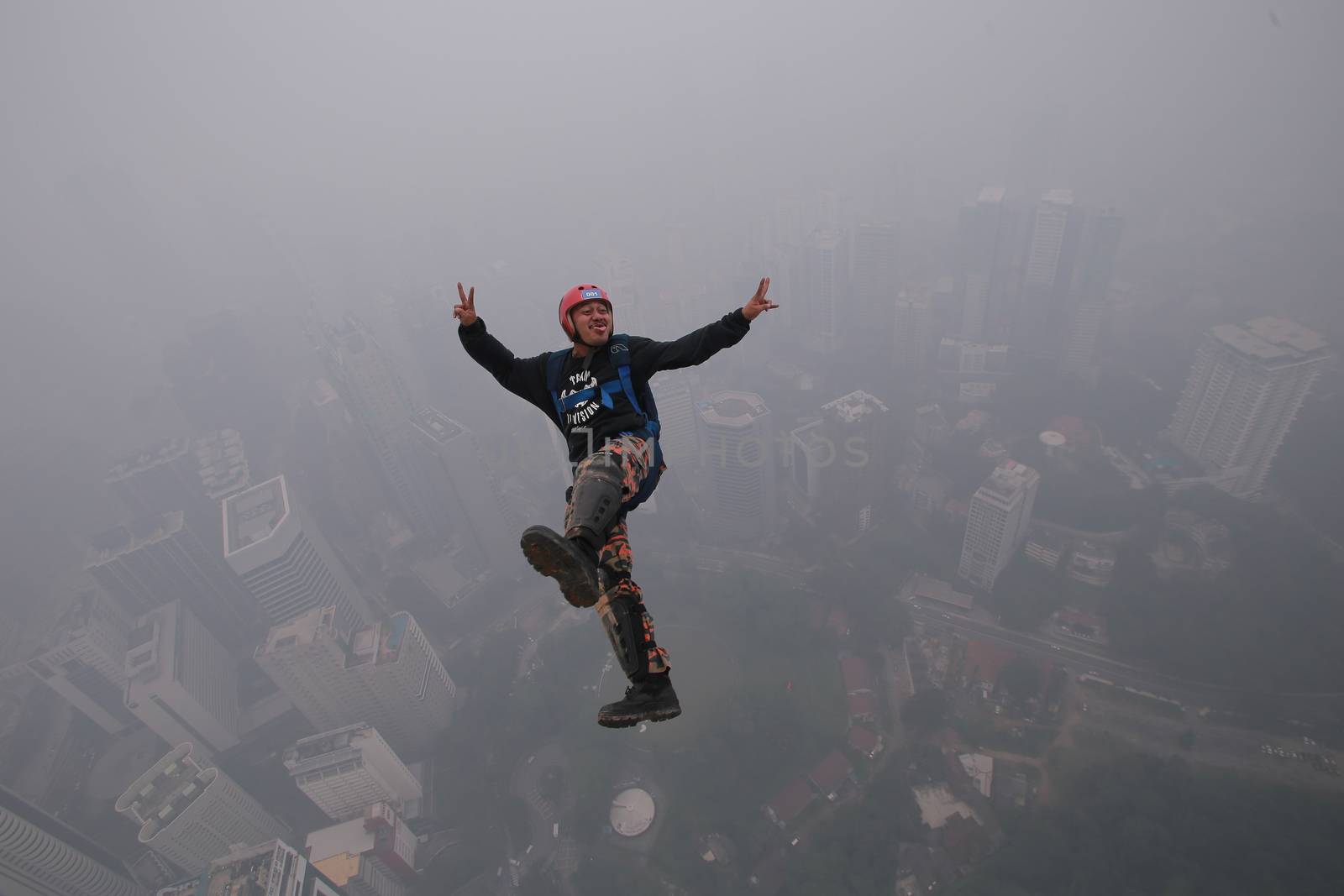 MALAYSIA, Kuala Lumpur: Base jumper 	Heavy haze didn't deter the 120 thrill-seeking base jumpers as they leapt into the foggy abyss off Kuala Lumpur Tower on October 3, 2015.  	The participants were joining others across the world on the 15th�International Base Jump Day. 