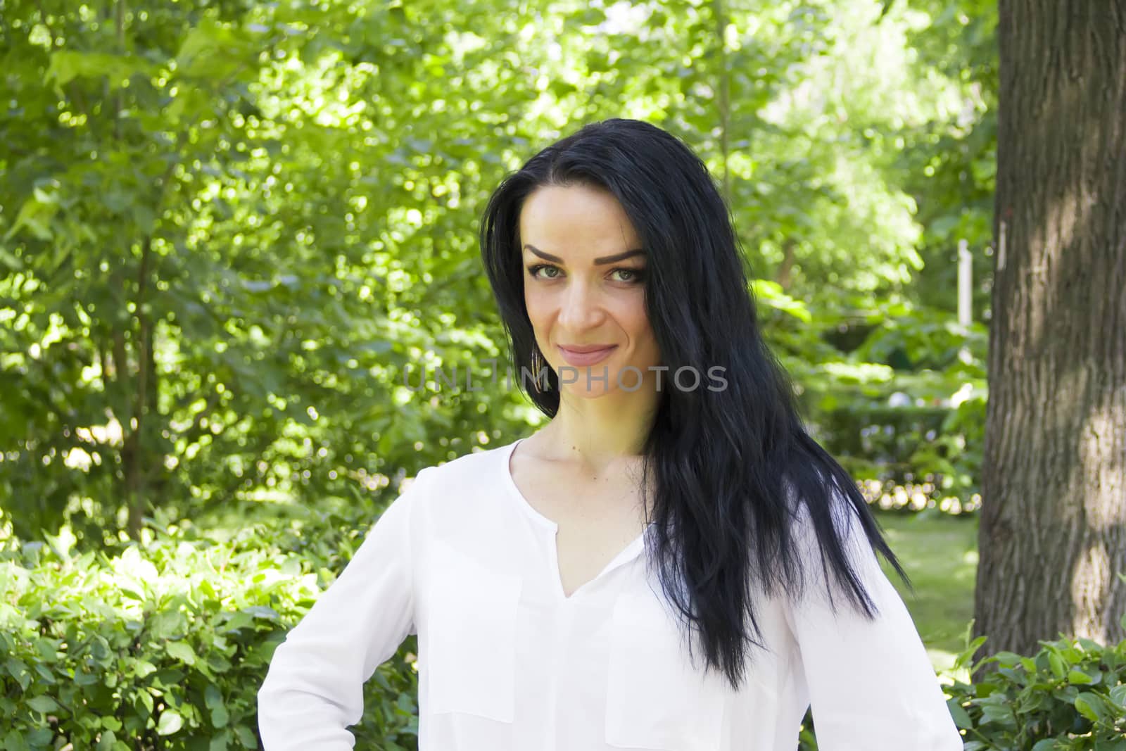 European woman with black hair on green background