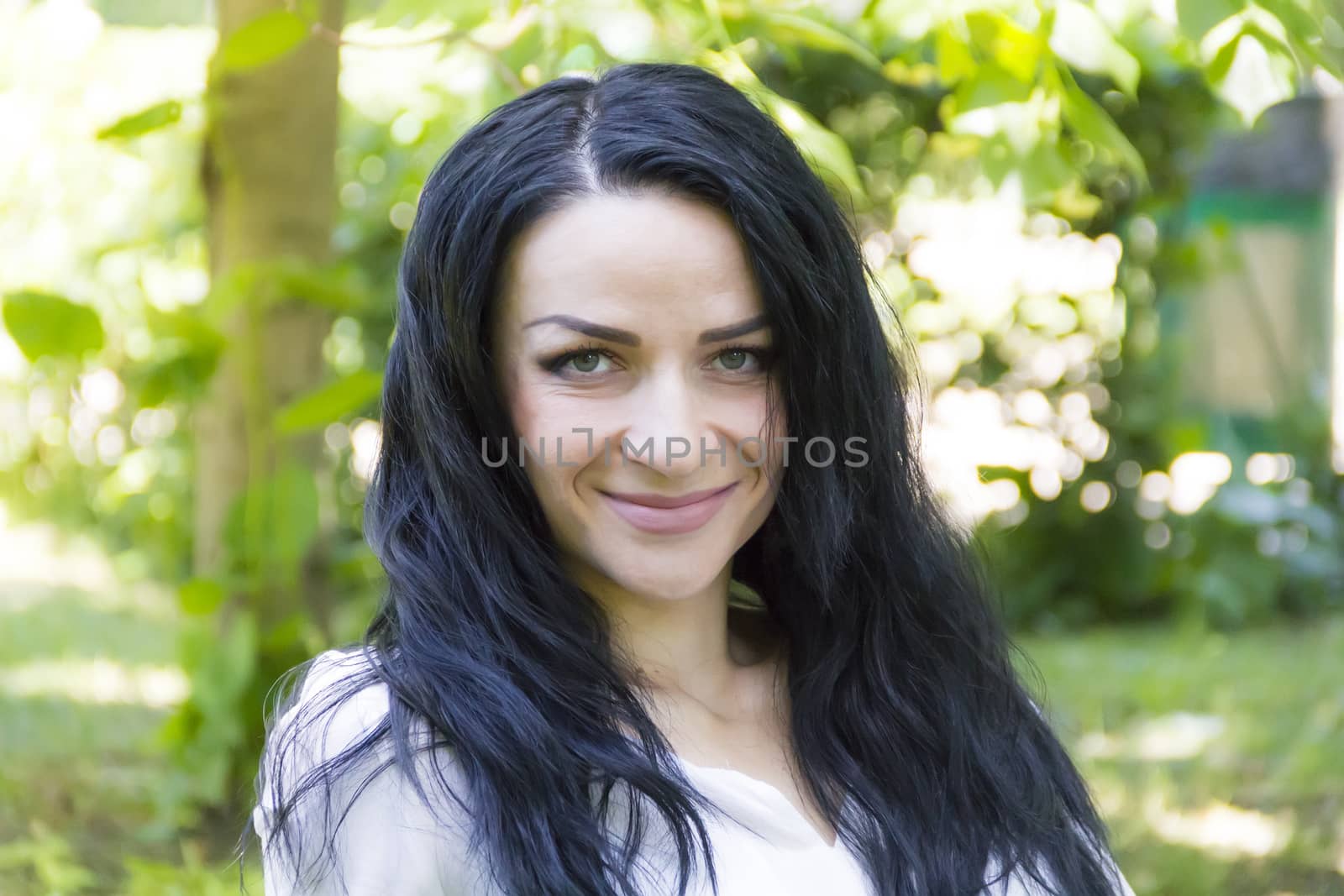 European woman with black hair on green background