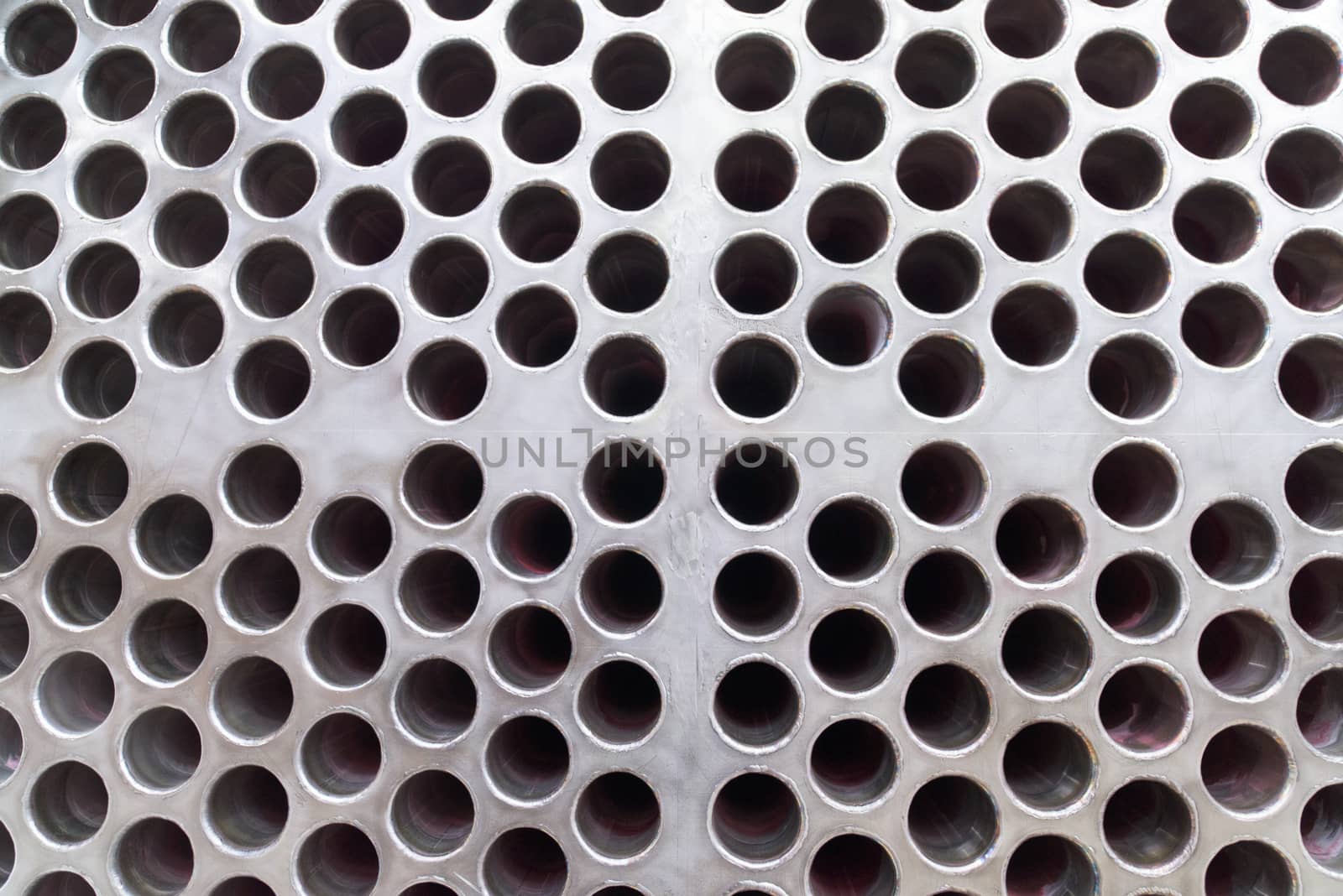 Steel plate with rough surface and drilled holes. Steel pipes connected to the holes on the back side.