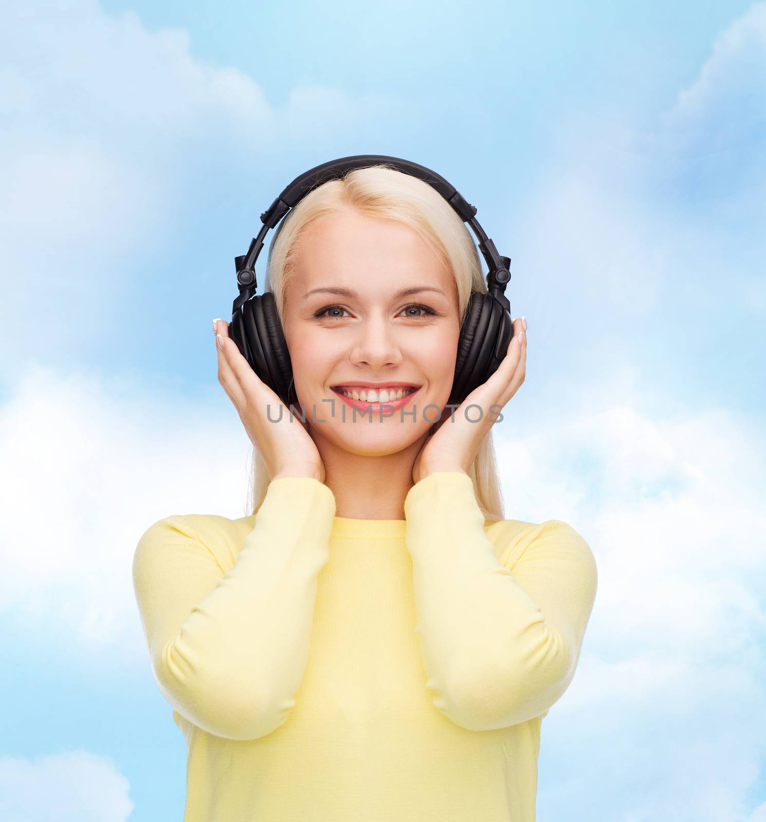 smiling young woman with headphones by dolgachov