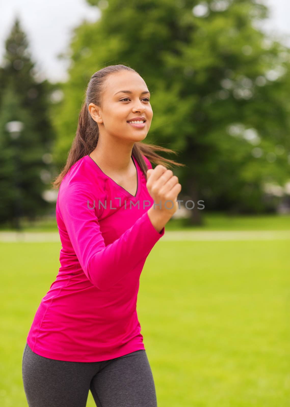 smiling young woman running outdoors by dolgachov