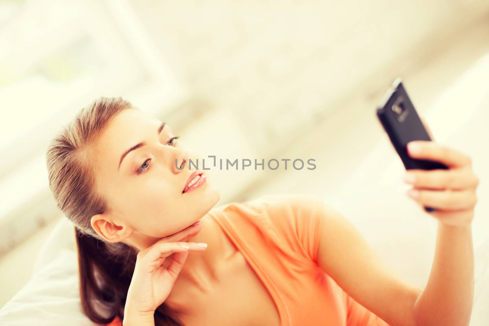 technology concept - woman making self portrait with smartphone