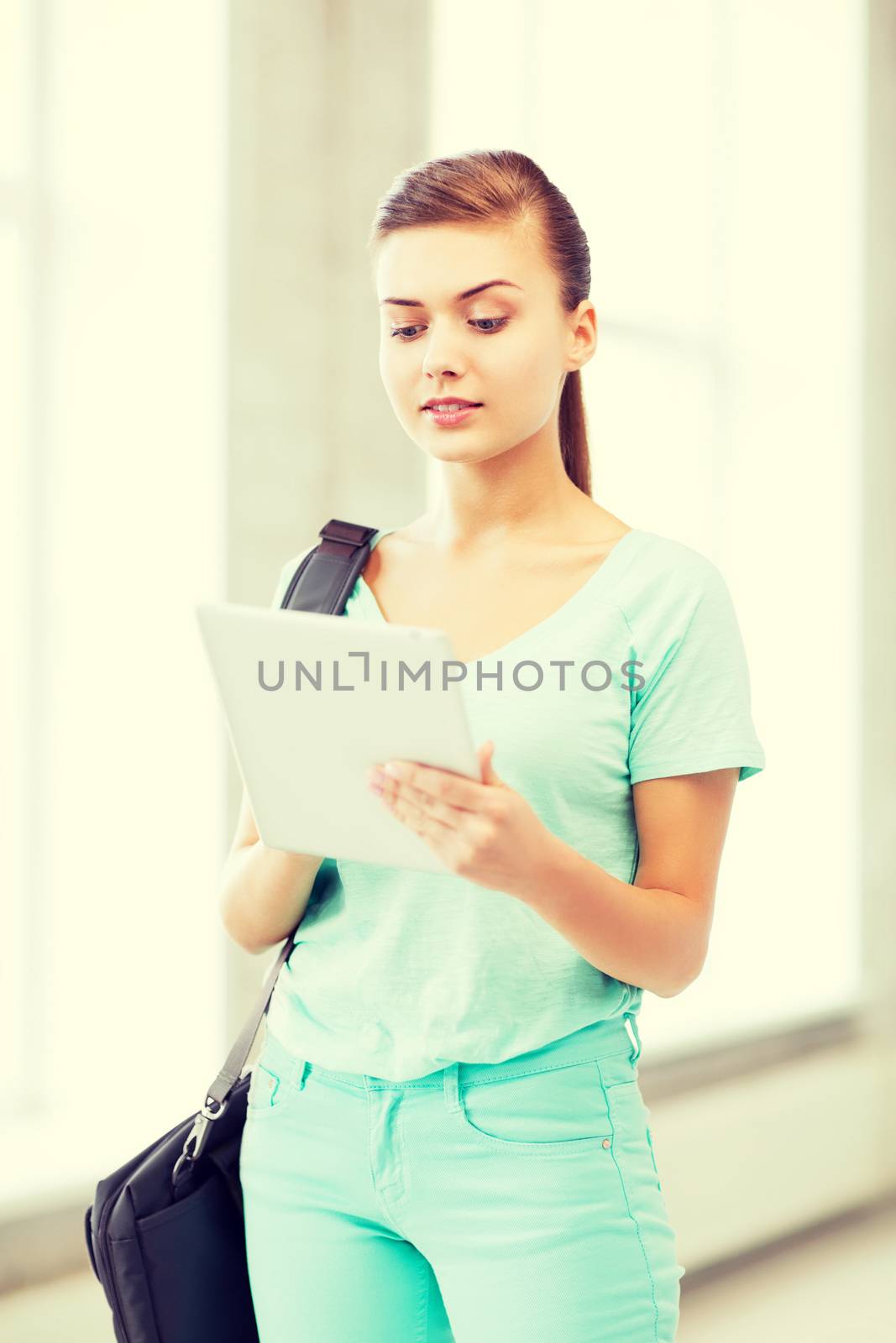 smiling student with tablet pc in college by dolgachov