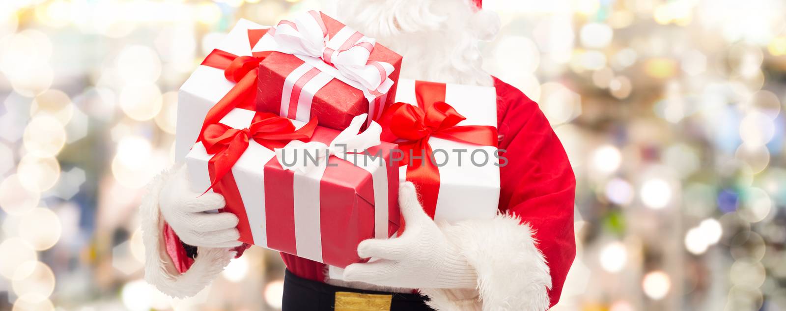 christmas, holidays and people concept - close up of santa claus with gift box over lights background