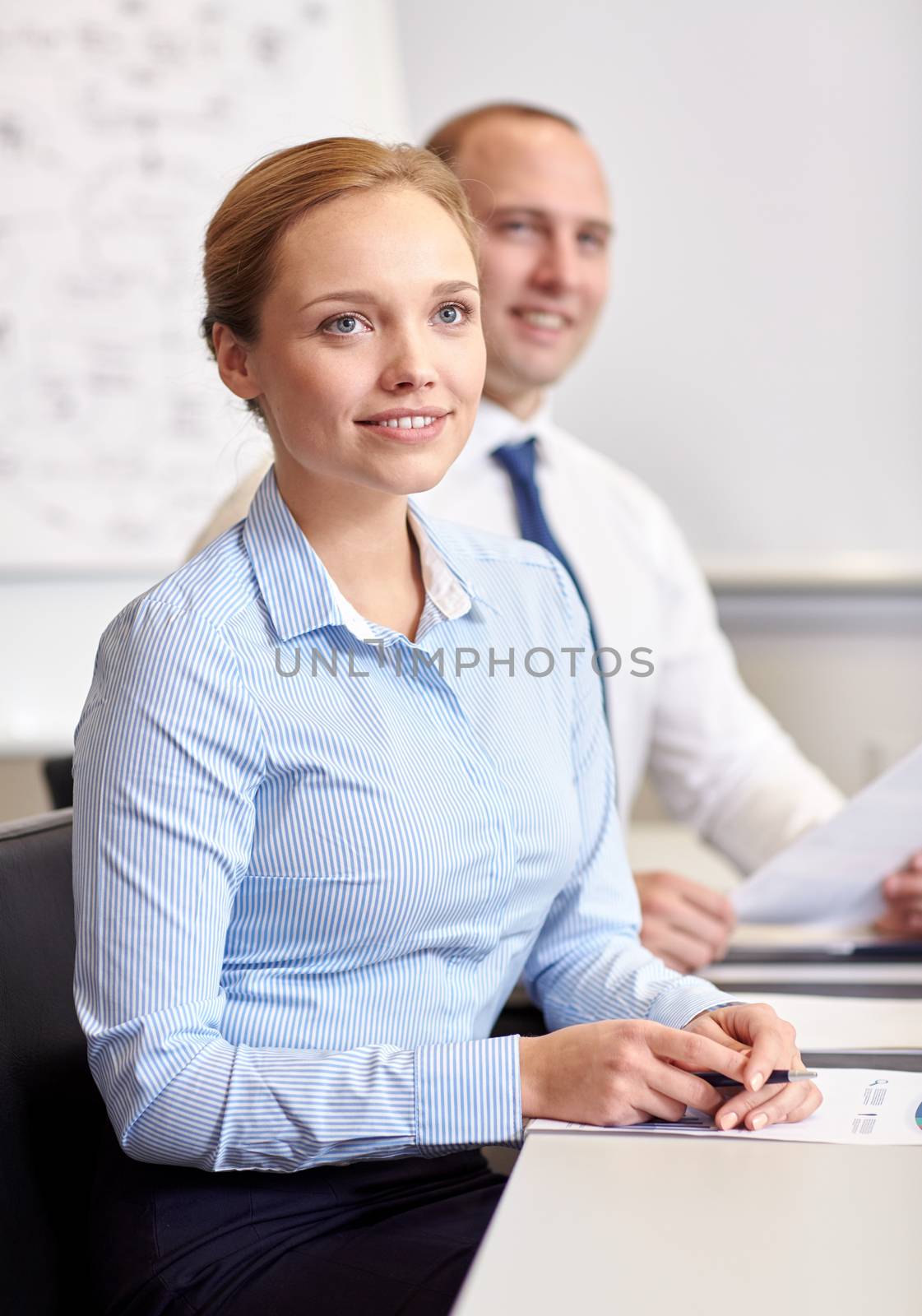 business, people and technology concept - smiling business team with papers meeting in office