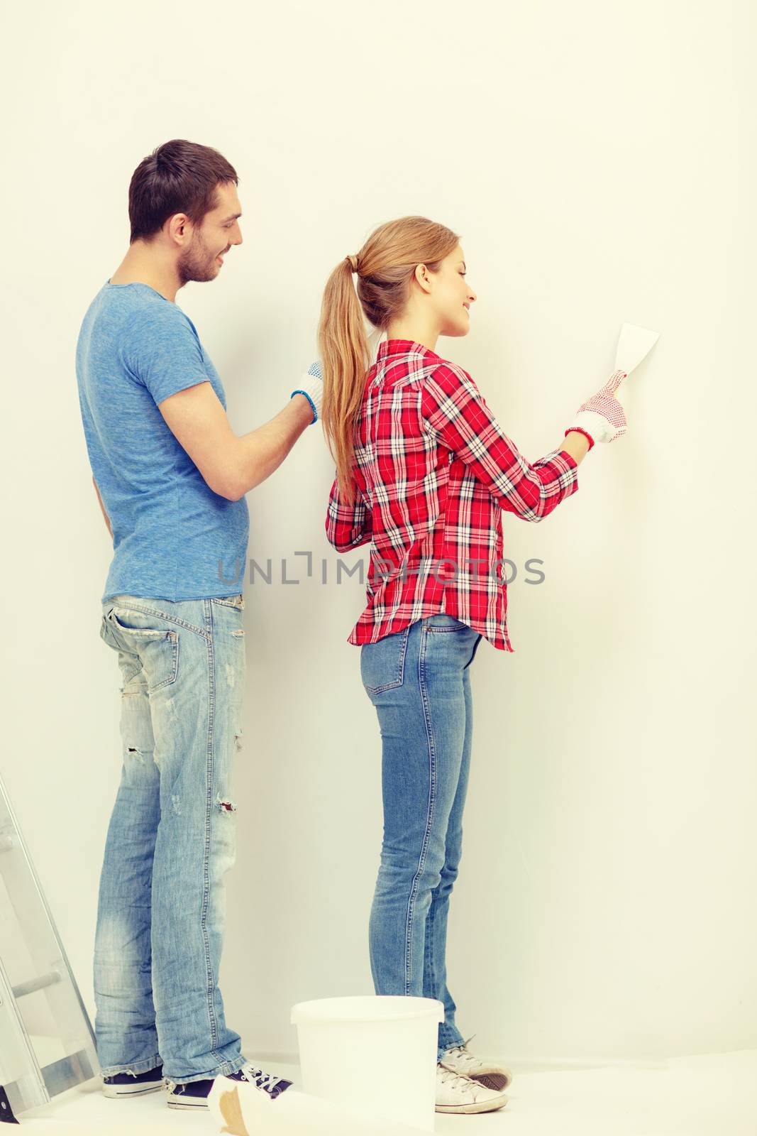 smiling couple doing renovations at home by dolgachov