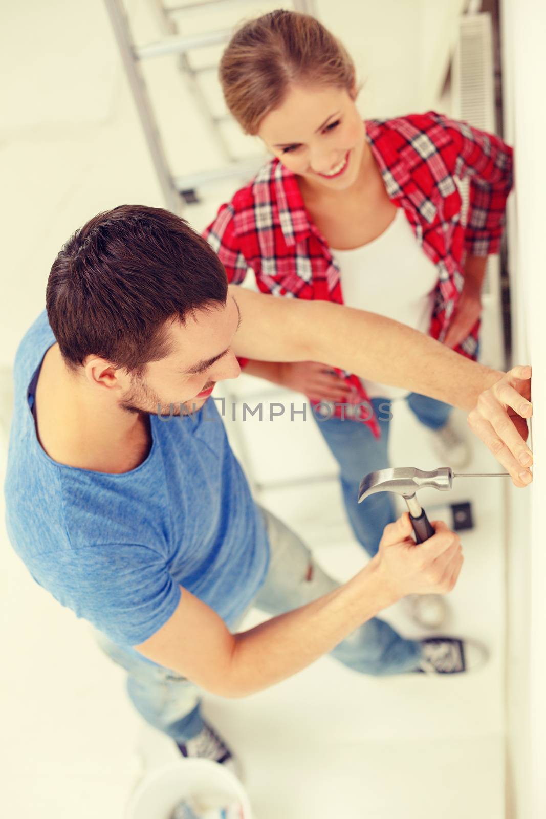 repair, building and home concept - smiling couple renovating new home
