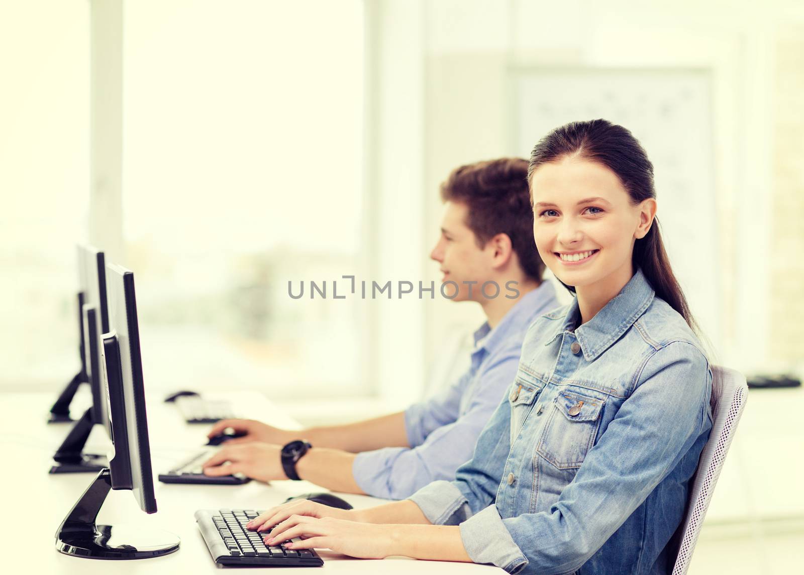 two smiling students in computer class by dolgachov