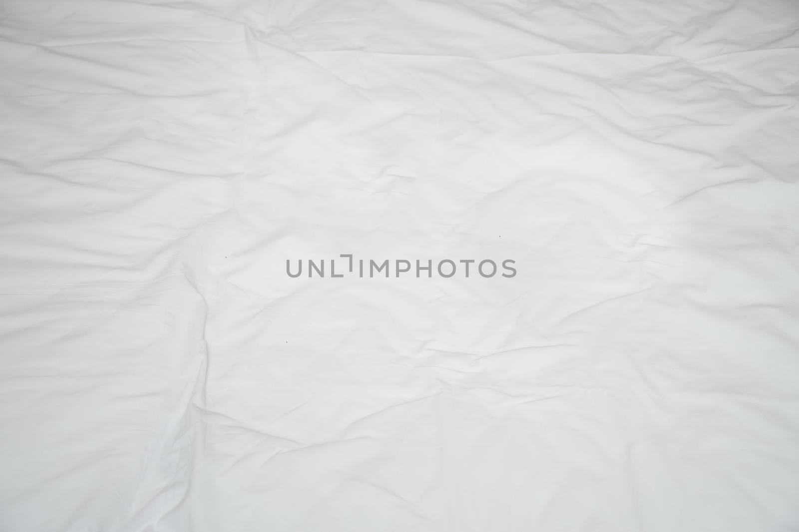 Old rumpled bed sheet with creases. View from above