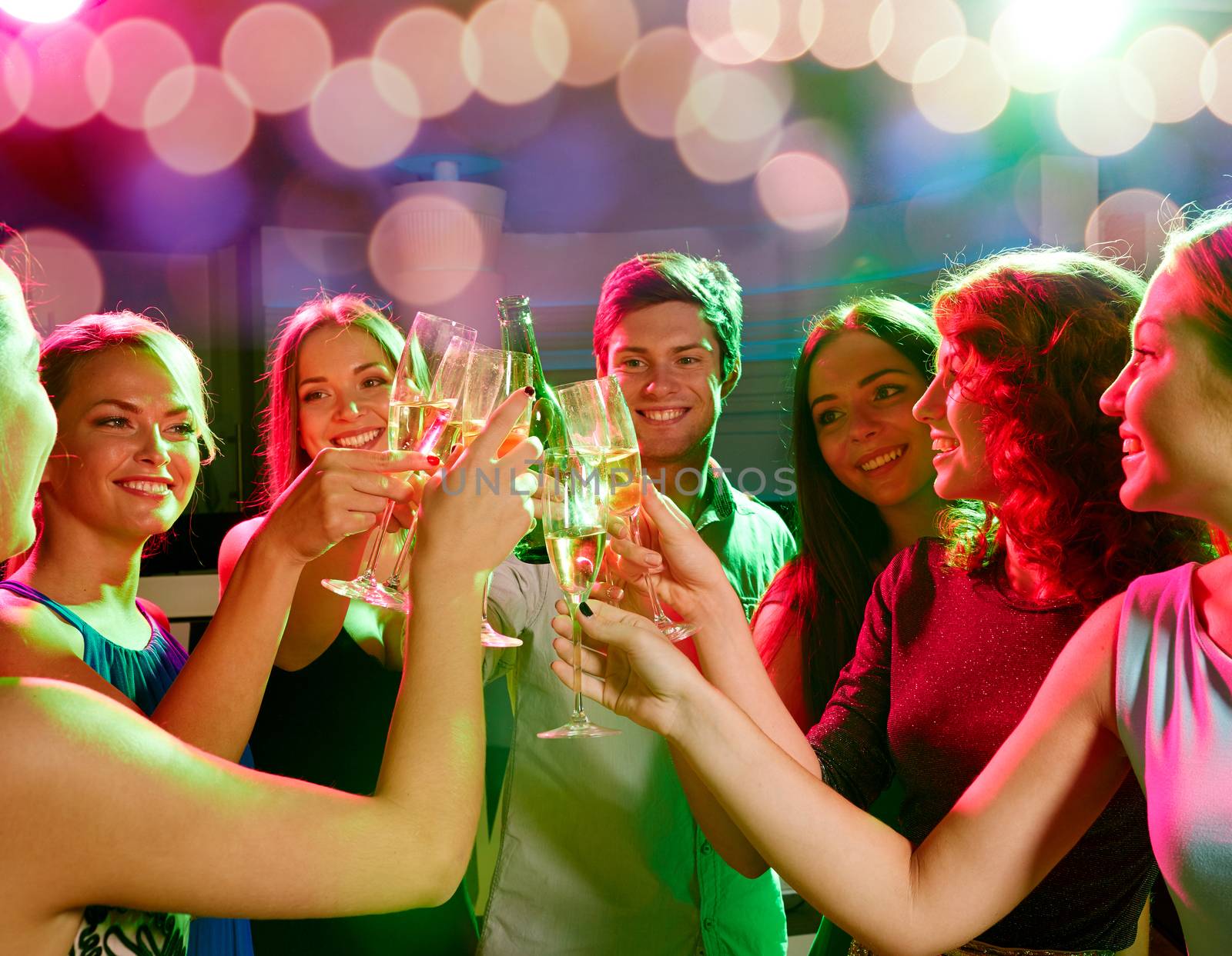 party, holidays, celebration, nightlife and people concept - smiling friends clinking glasses of champagne and beer in club