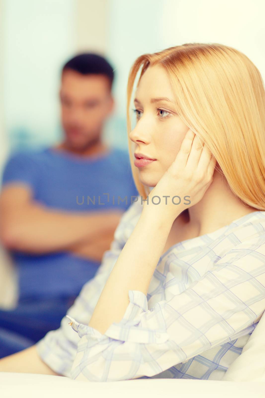 upset young woman with man on the back at home by dolgachov