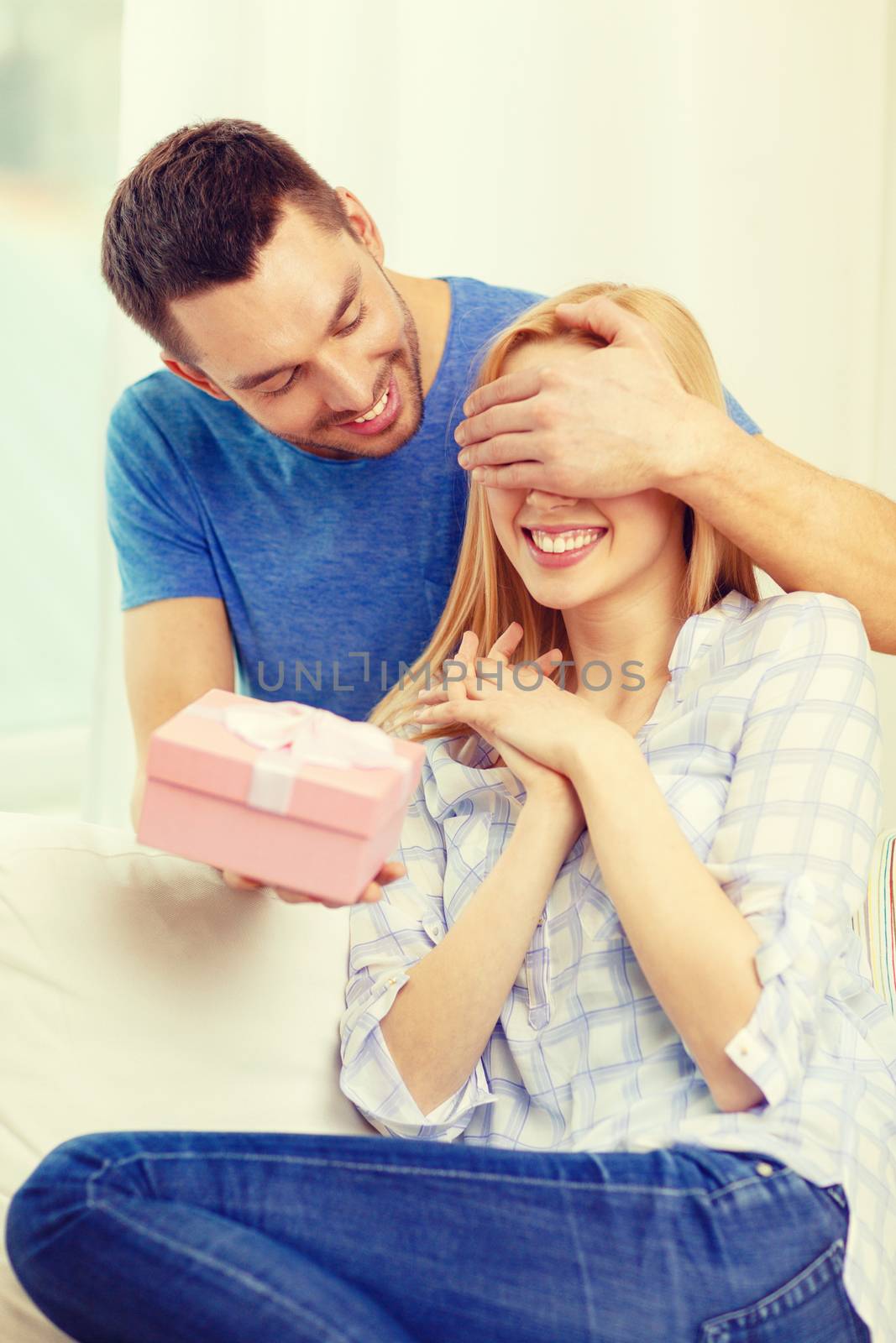 smiling man surprises his girlfriend with present by dolgachov