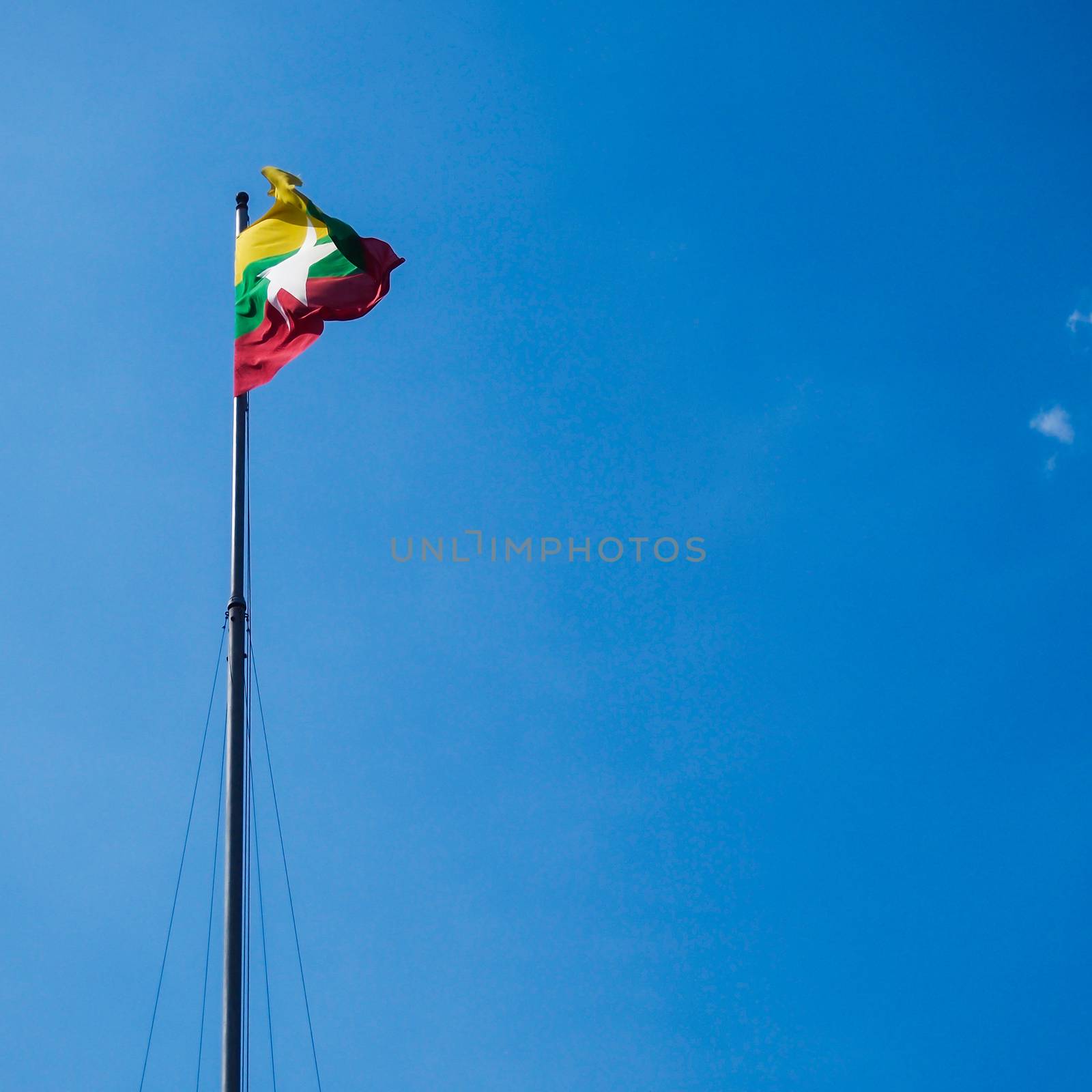 Kanchanaburi, Thailand - JMarch 6, 2011 : Myanmar flag waving on the wind in the blue sky , Kanchanaburi , Thailand