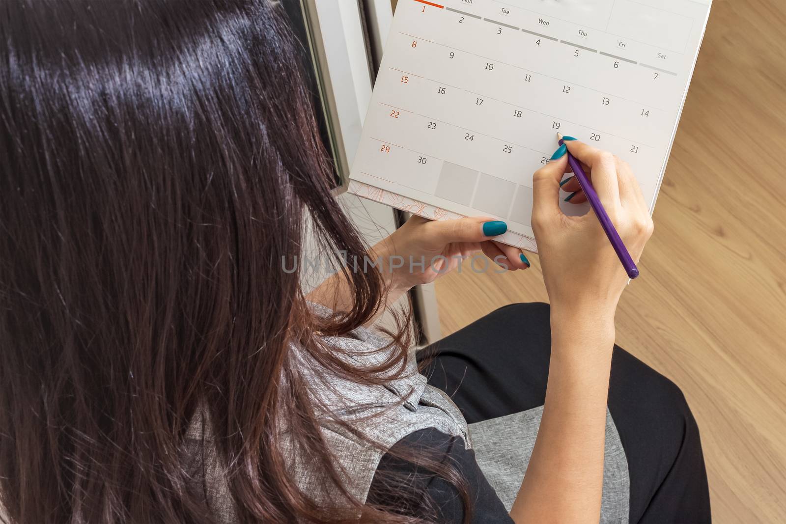 woman holding pencil on calendar for  making appointment  import by FrameAngel
