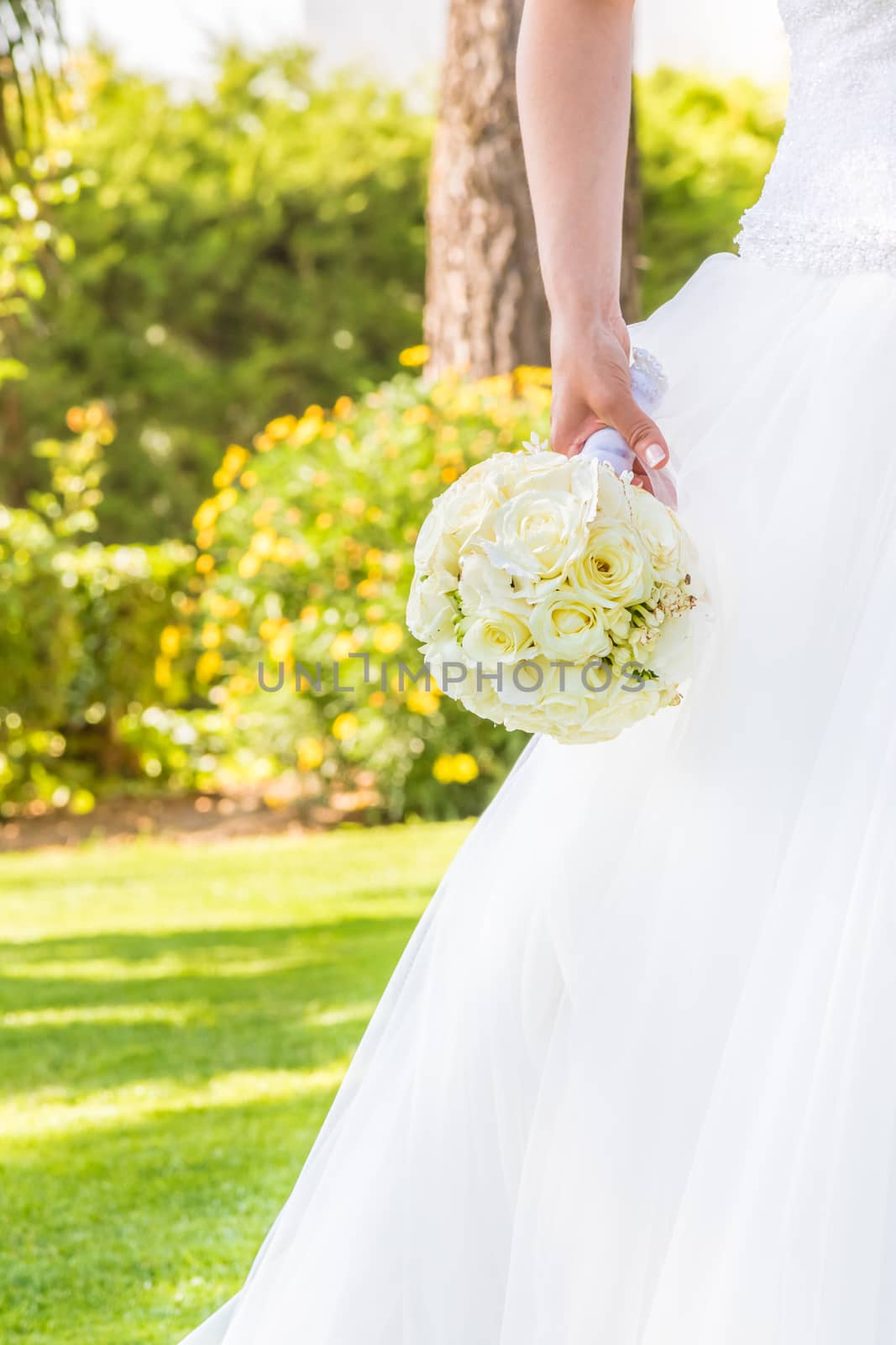 detail of bride holds in hand a wedding bouquet of flowers in a garden by donfiore