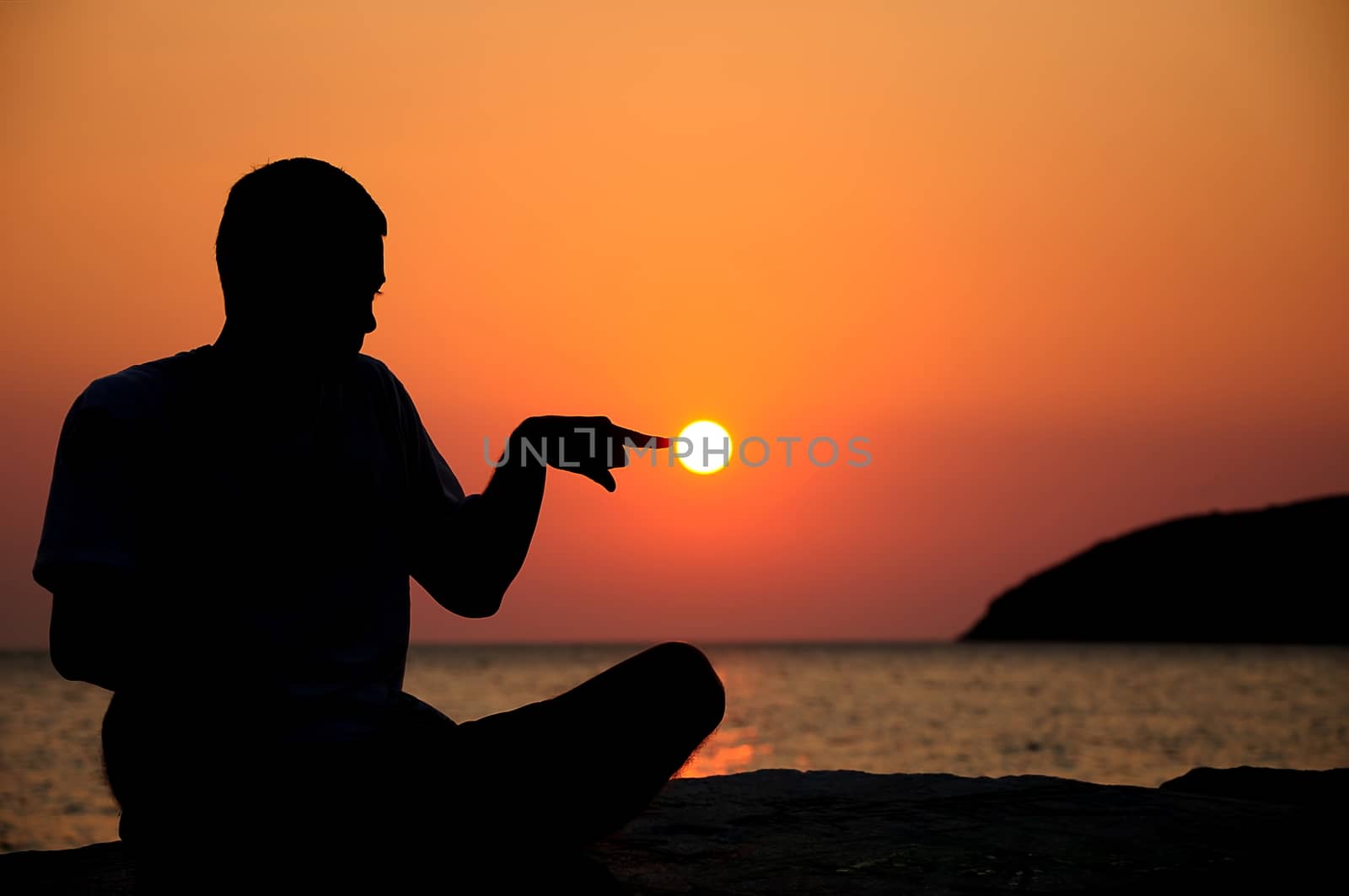 silhouette of an young man on sunrise and sea on background